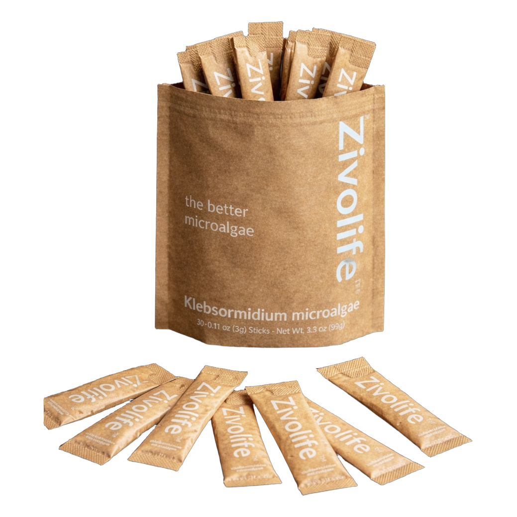 A kraft paper Zivolife pouch holds several individual microalgae stick packets, with more scattered in front.