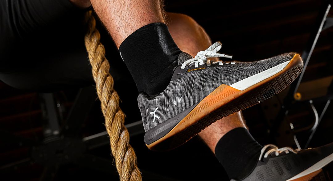 Closeup of man wearing Flux shoes in a dark gym environment