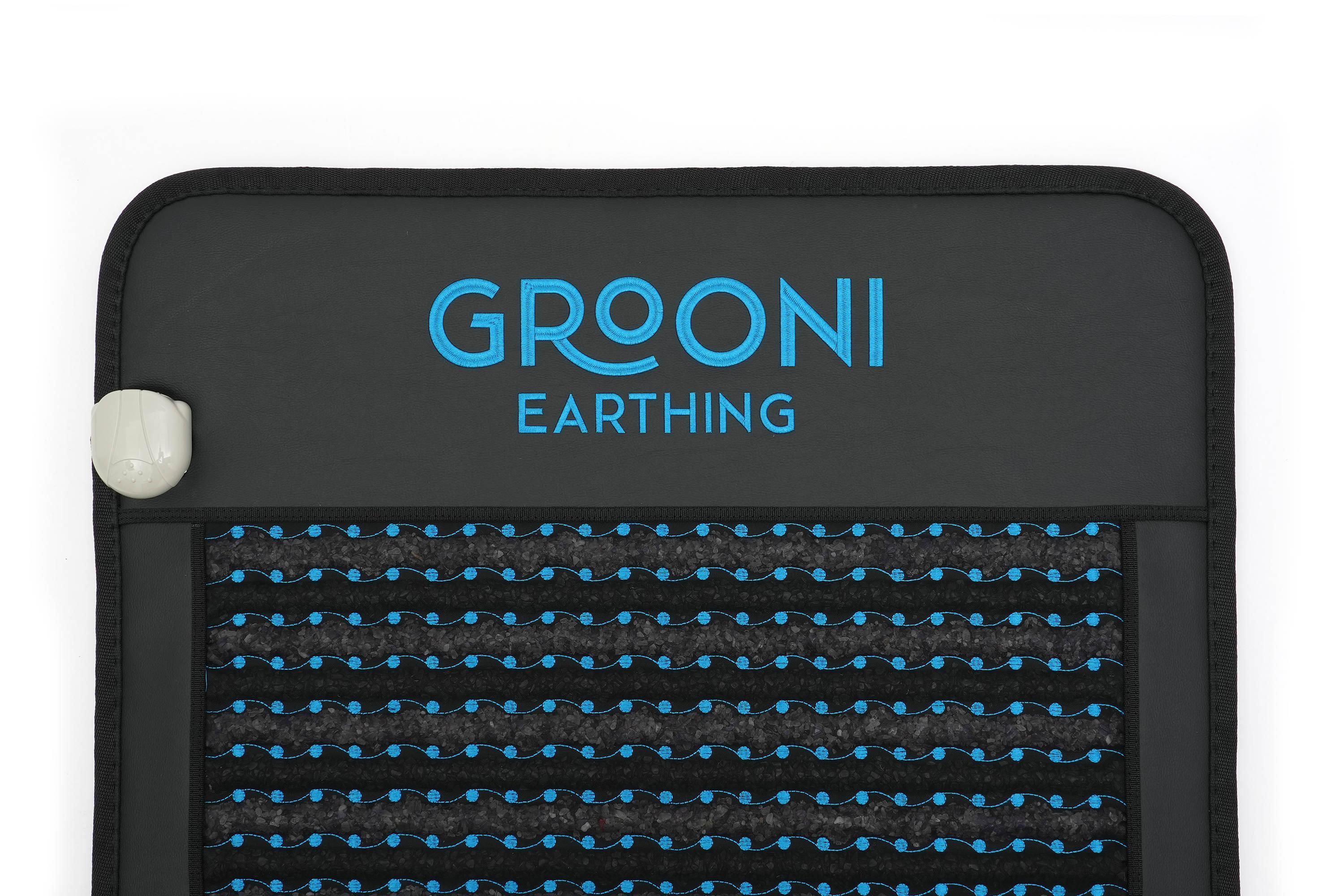 Dark grey mat with blue 'GROONI EARTHNG' text, wavy blue lines and dots, and a white connector.