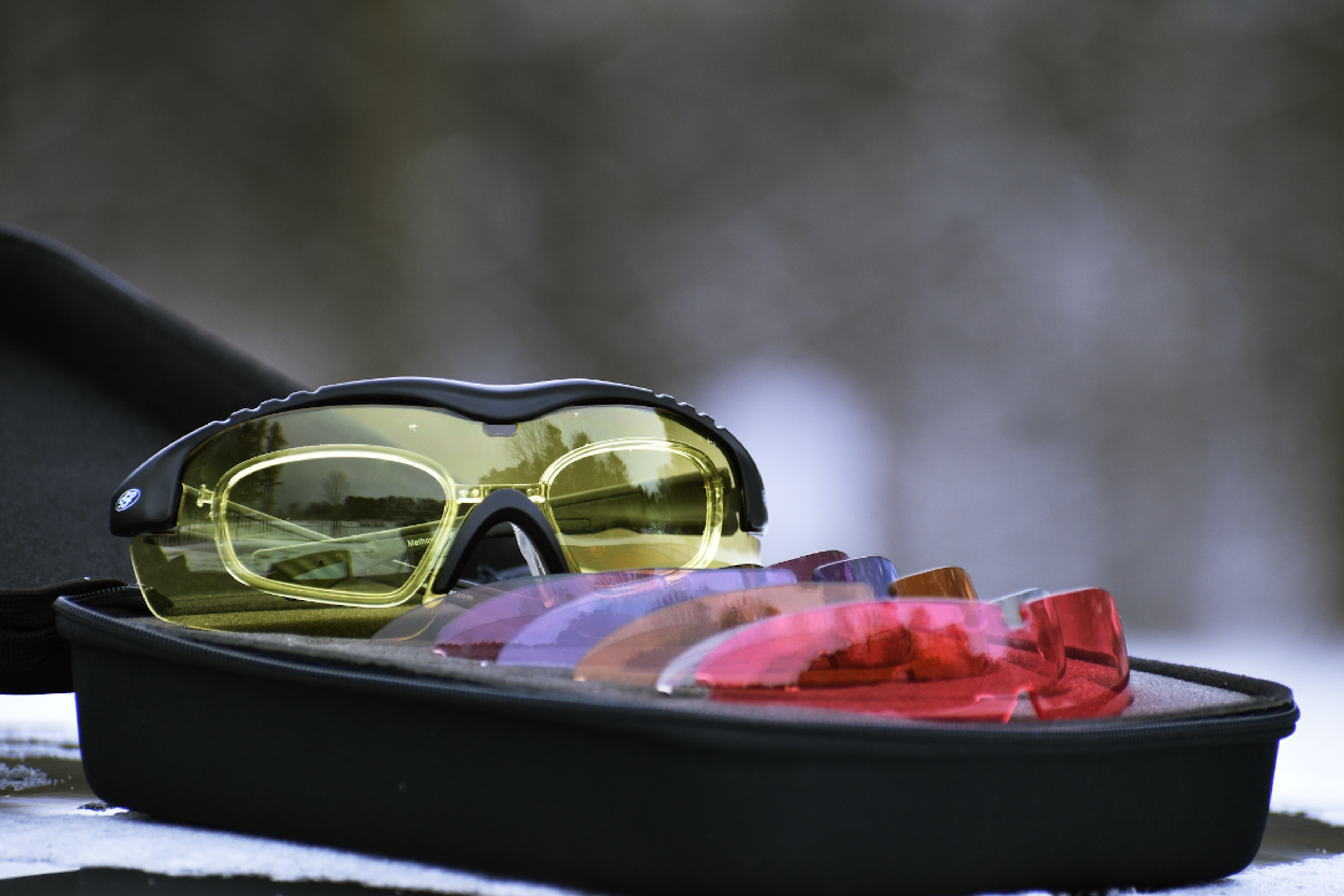 Yellow sports glasses and a case of interchangeable colored lenses.