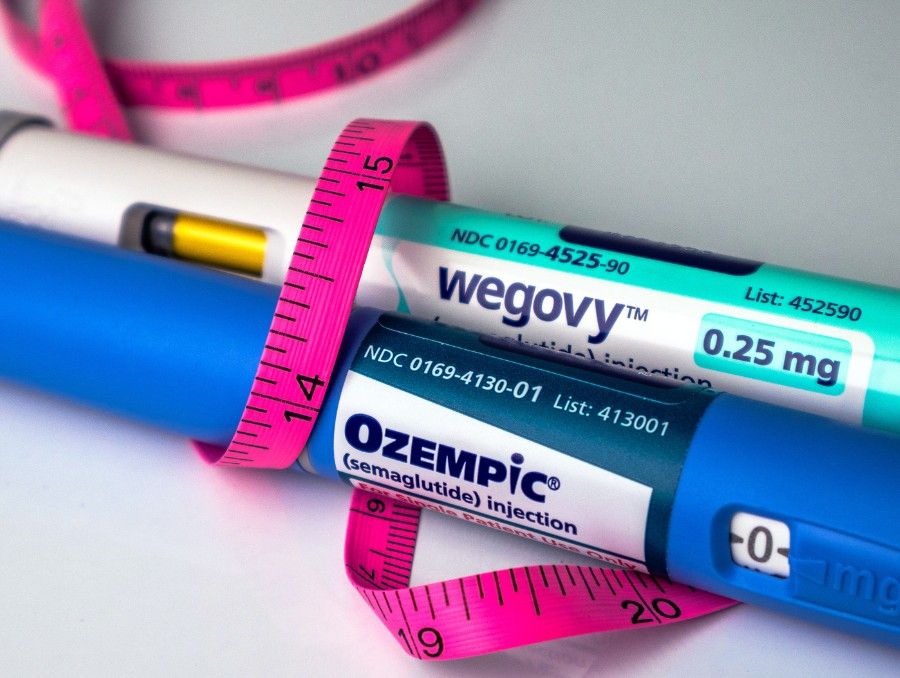 Penne iniettabili di farmaci GLP-1 accanto a un metro da sarta per un percorso di gestione del peso