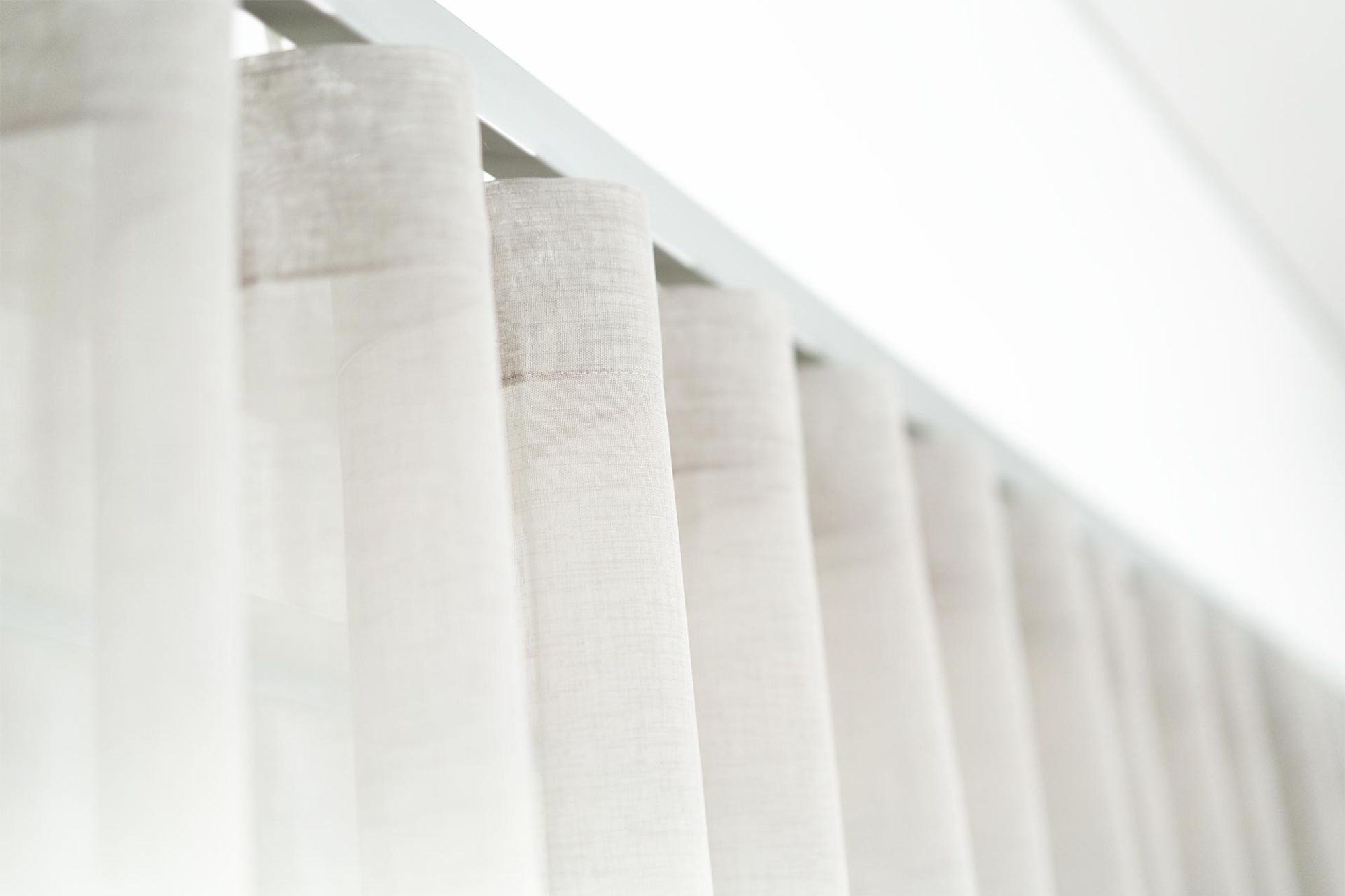 Sheer curtains keeping a bright living room cool in summer