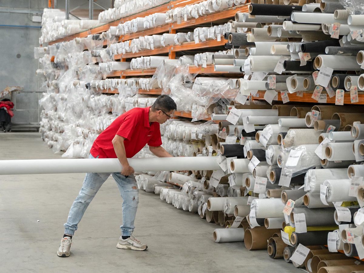 A Curtain World team member with fabric rolls in the Malaga warehouse