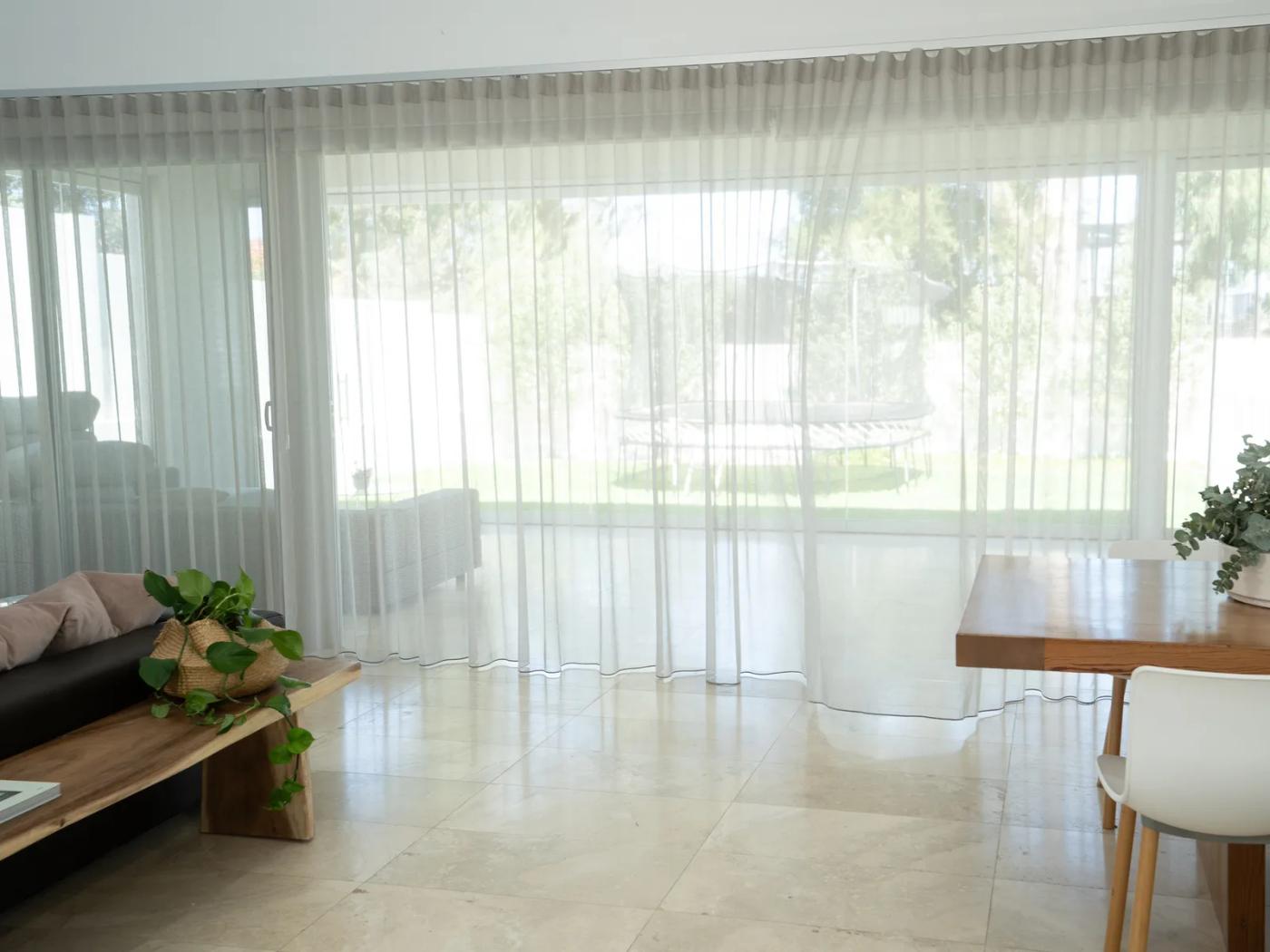 Sheer curtains across a bright open-plan room