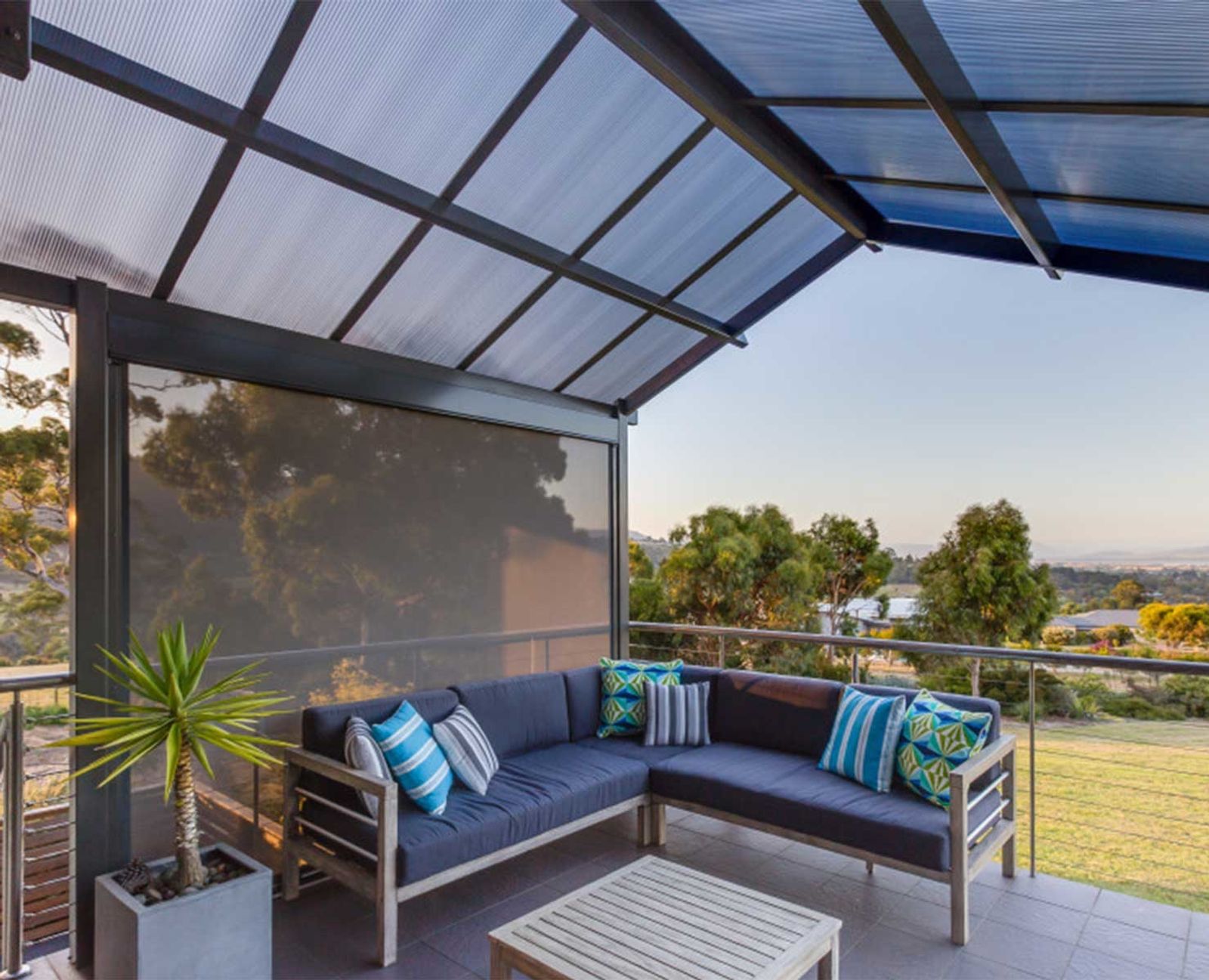 Outdoor blind lowered beside an outdoor lounge on a covered patio