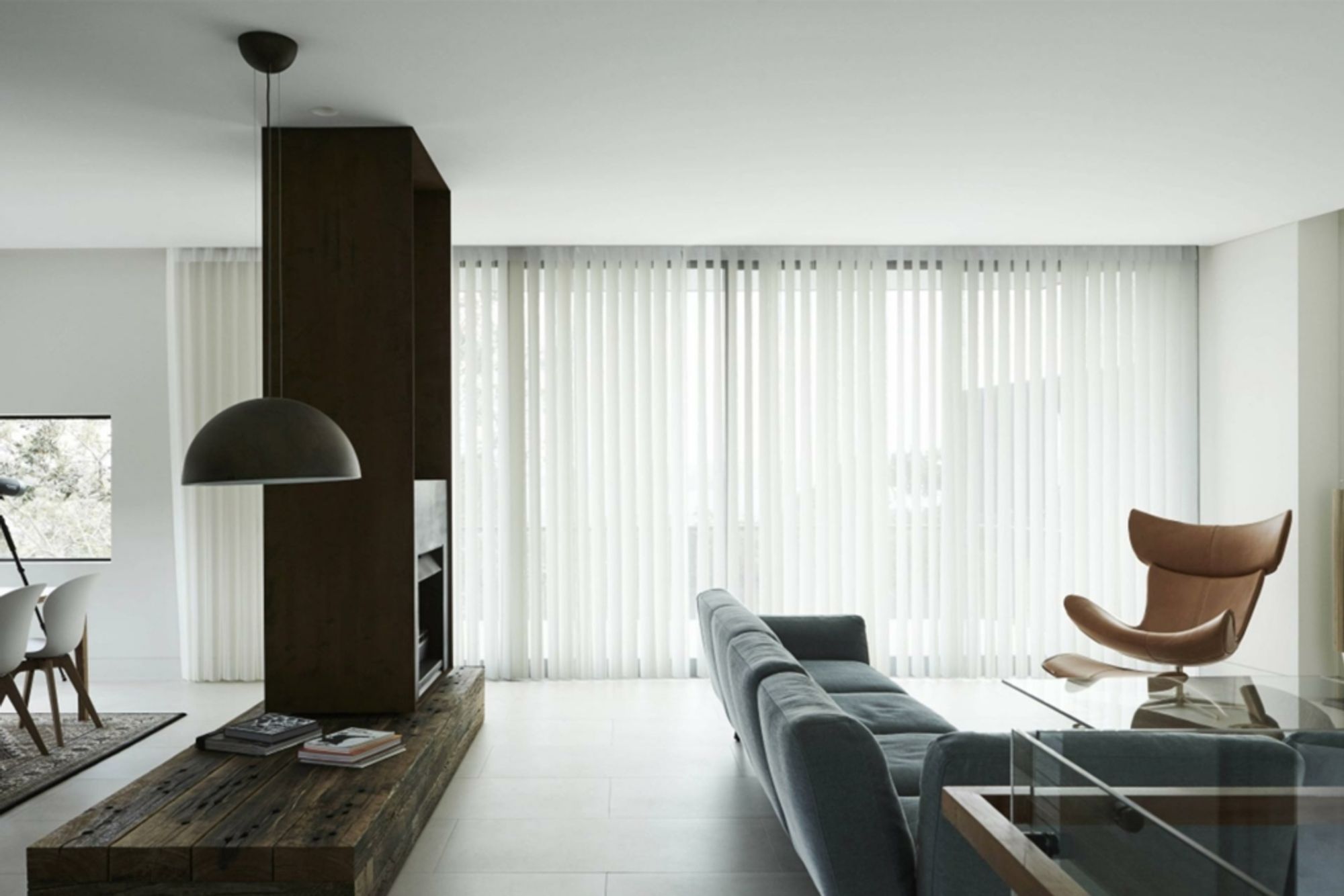 A minimalist living room with white Veri Shades drawn across a full-width window