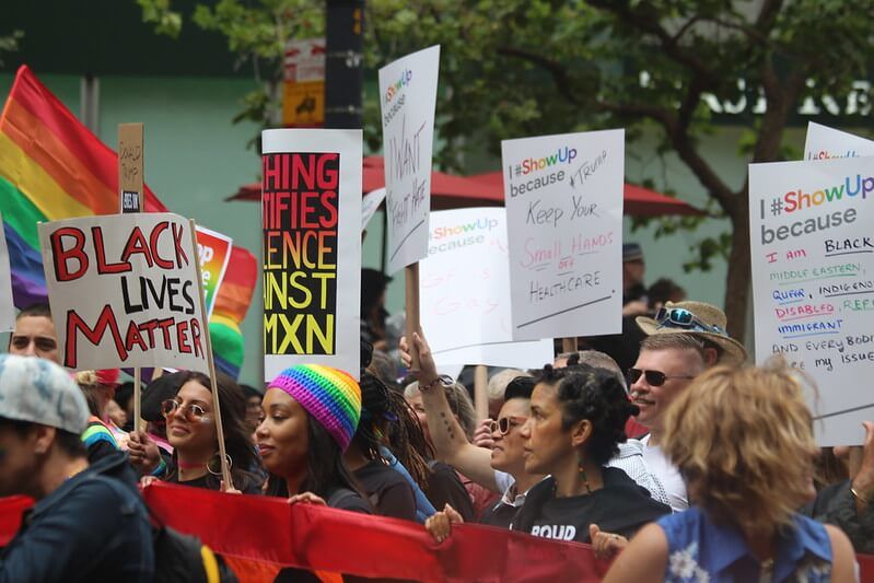 Black Lives Matter protest with pride flags.