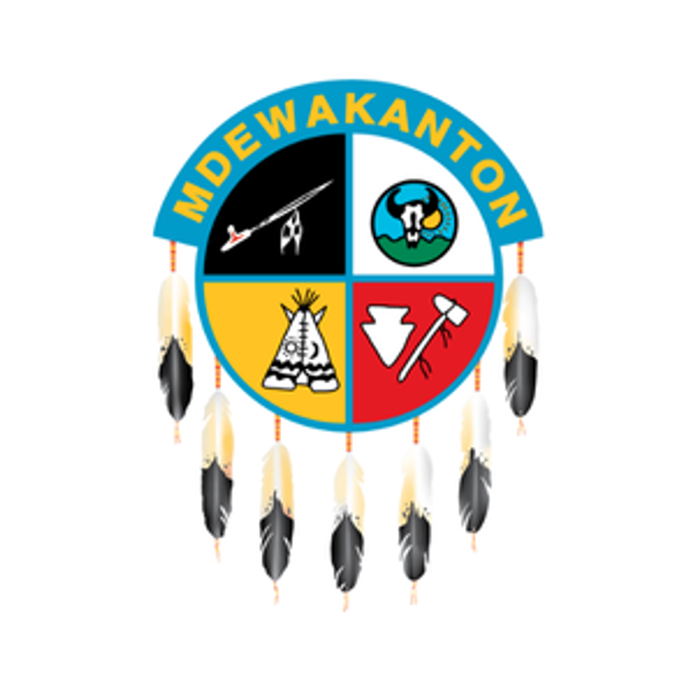 Shakopee Mdewakanton Sioux Community seal, a shield with different icons in each of the four quadrants, eagle feathers hang below
