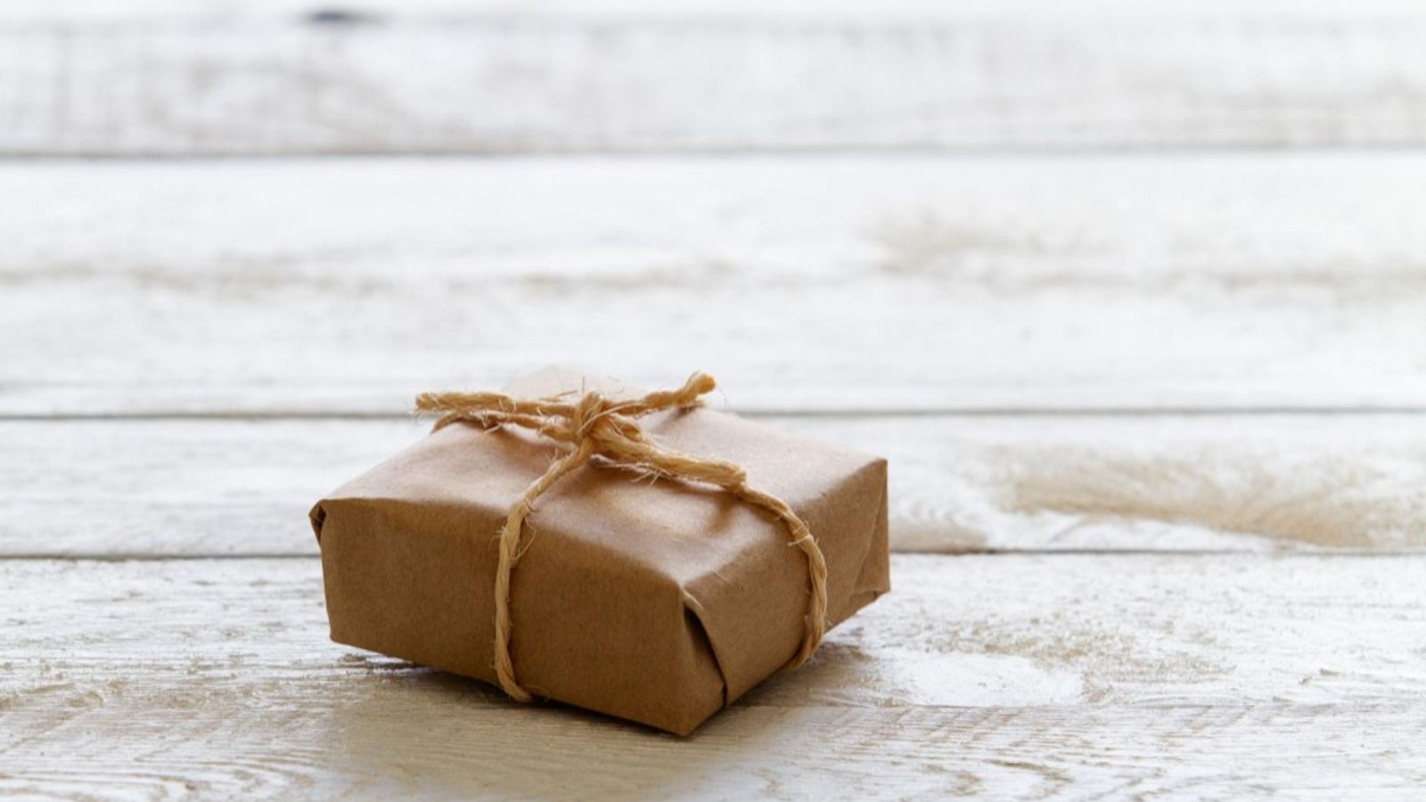 Minimal wrapped package on a clean surface, symbolizing a completed purchase