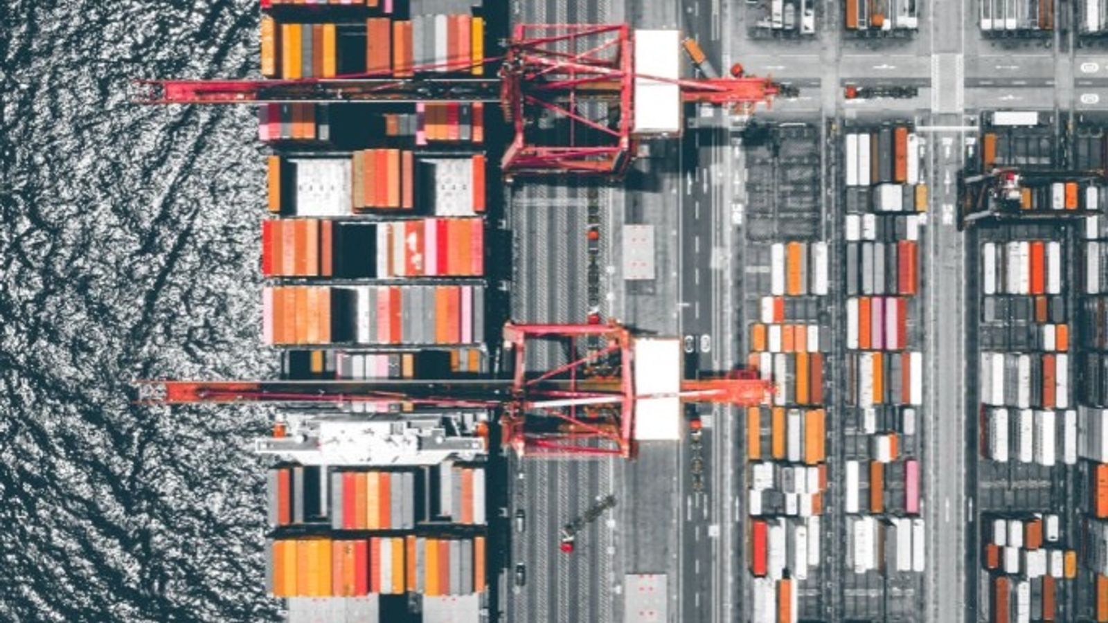 Aerial view of a shipping port with container ship, gantry cranes, and stacked containers representing international trade and customs clearance