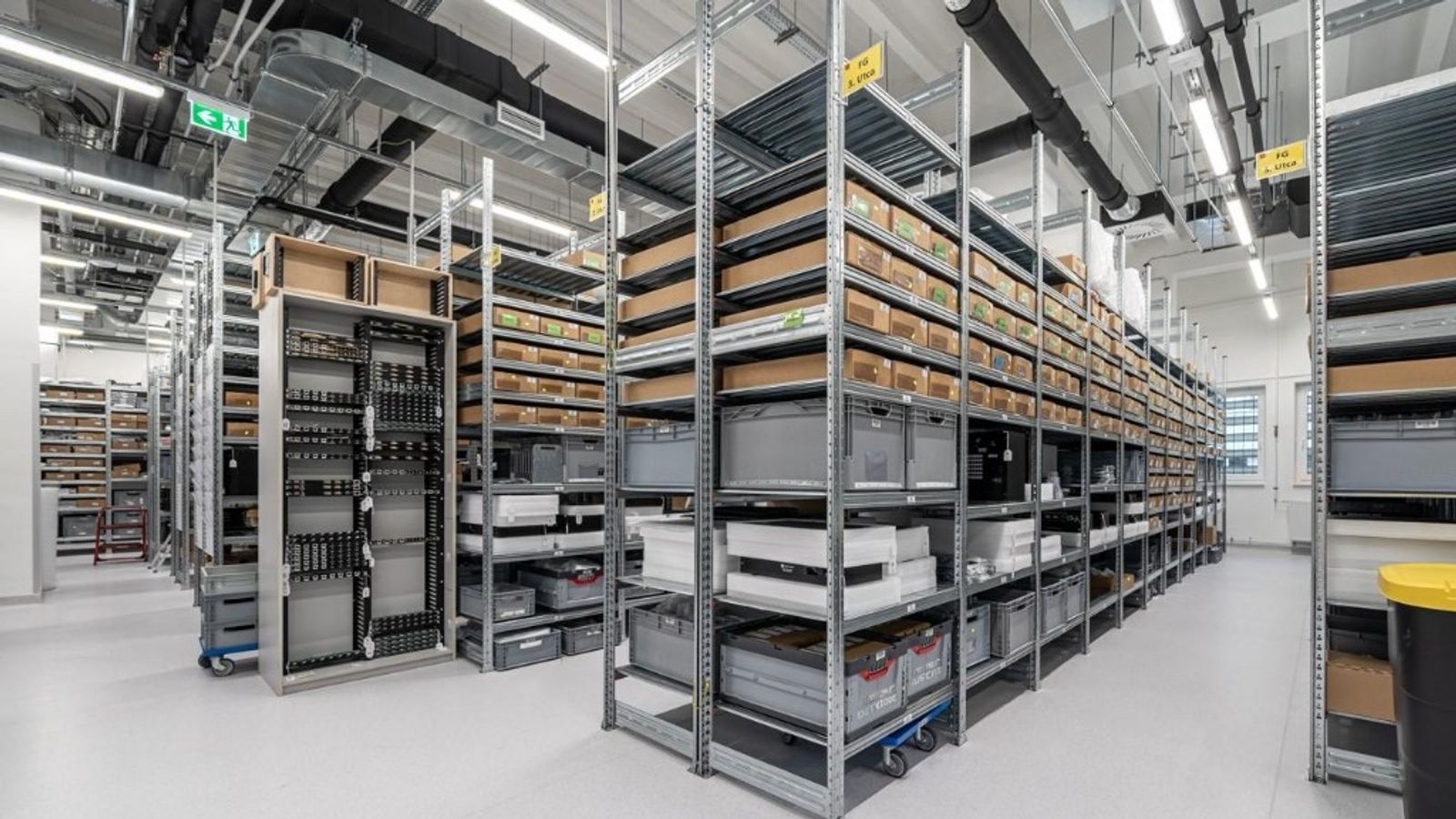 Modern warehouse with organized metal shelving and inventory, representing structured purchasing and supply chain management