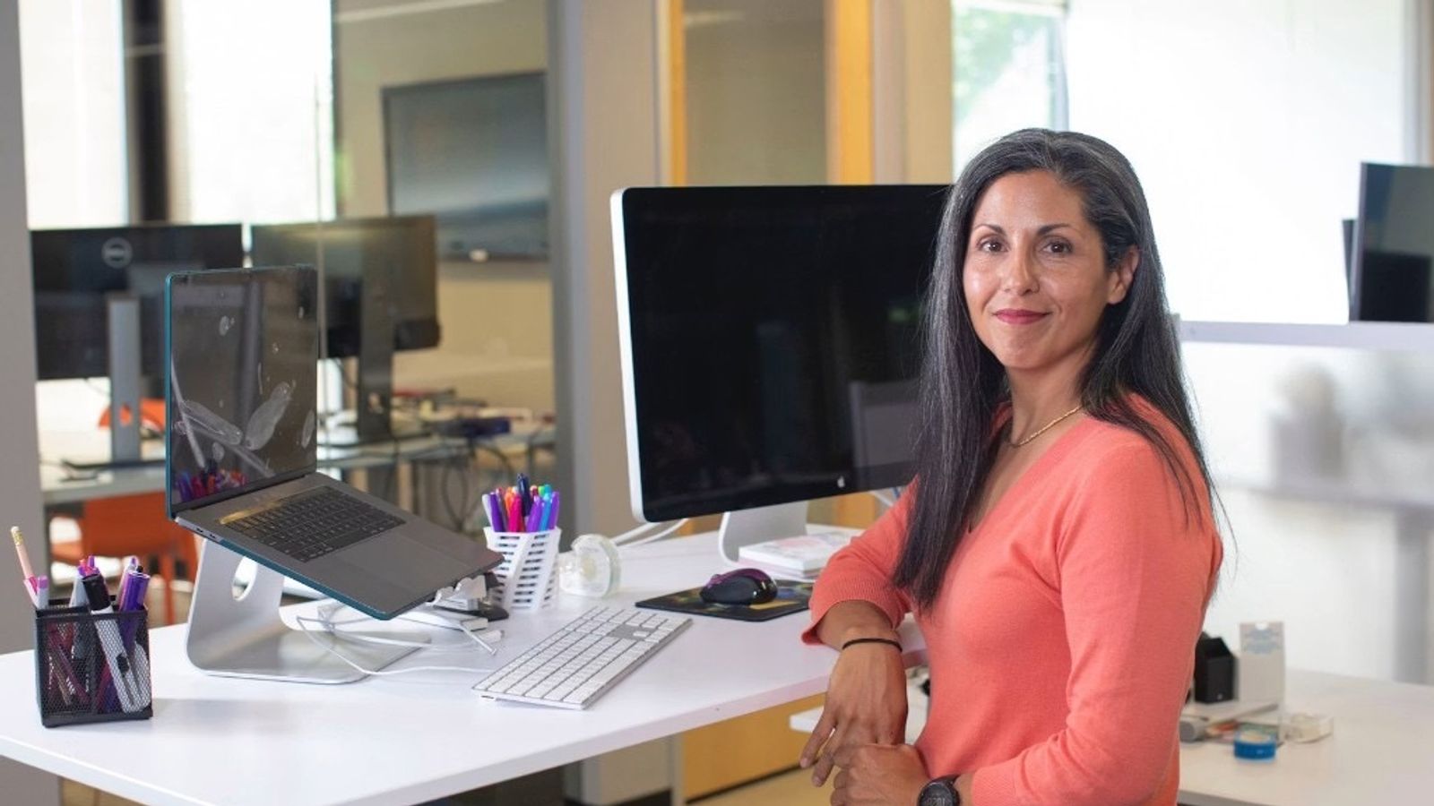 Woman at a standing desk in a modern office, representing small business cash flow management