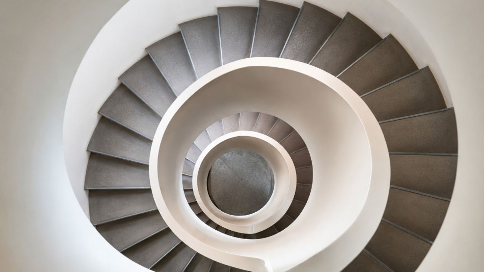Top-down view of a modern spiral staircase, suggesting recurring cycles and the turnover of receivables into cash