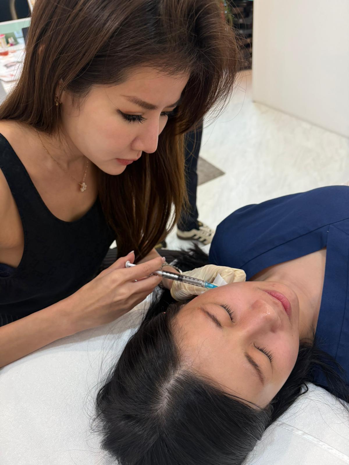 Dr Samantha Tay administering an anti-wrinkle injection on a patient's forehead at Nexus Aesthetic Clinic Singapore