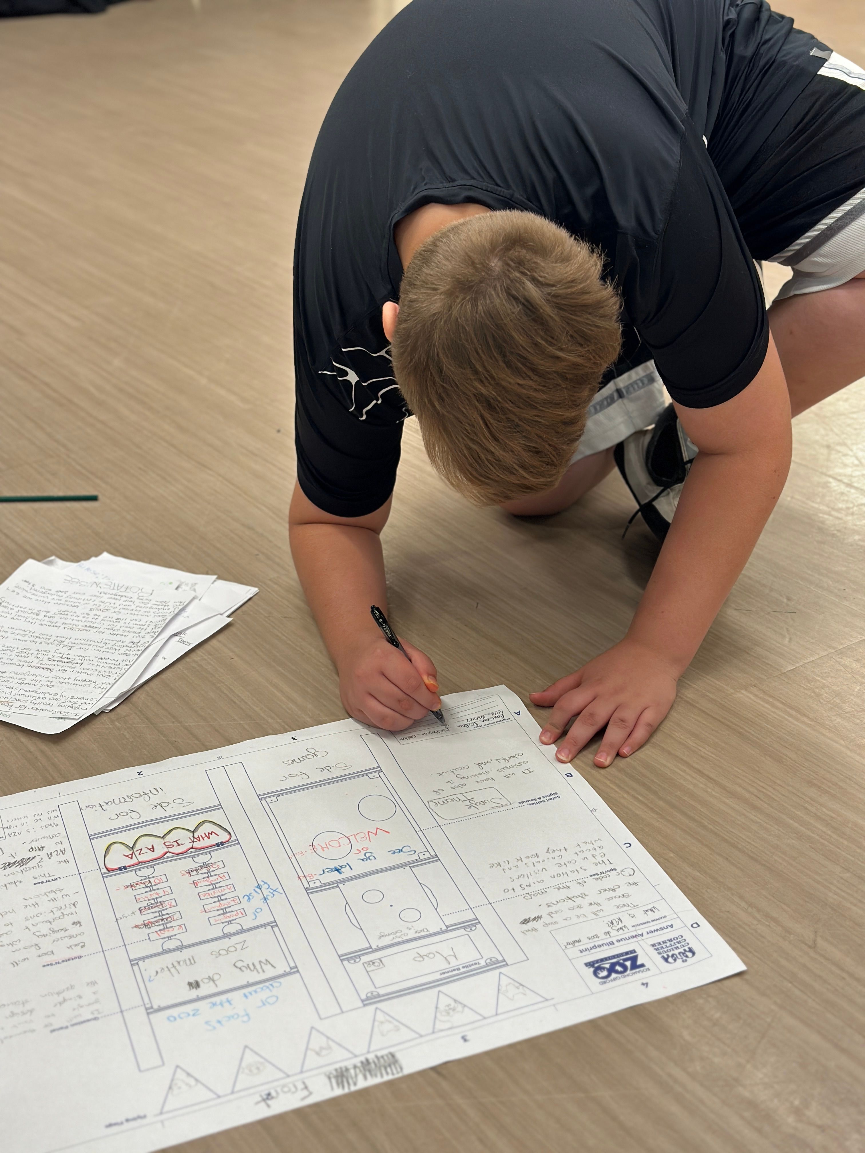 Taking all their research, a students fills in a blueprint, for approval.