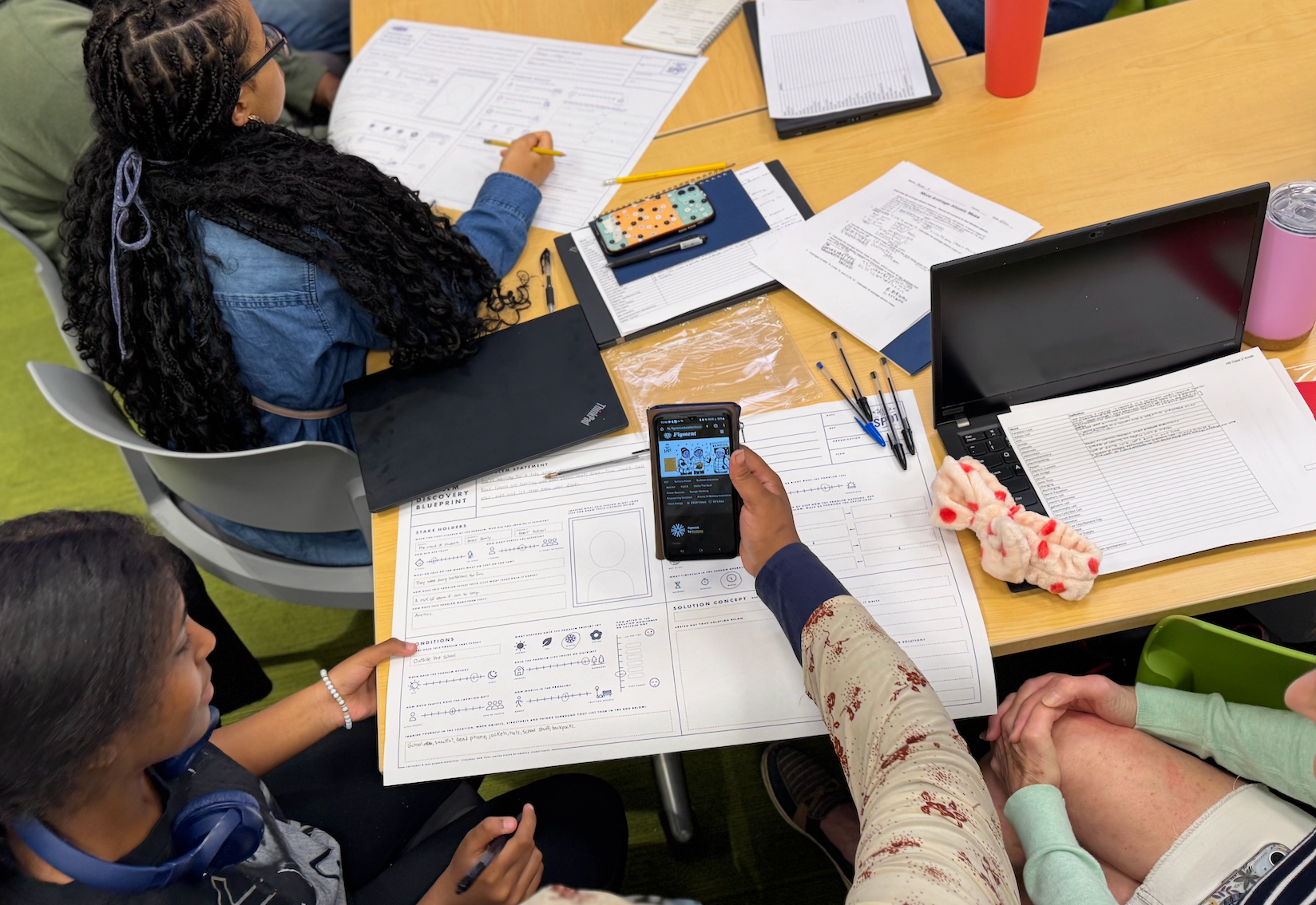 Students using blueprints to sketch power beacon concepts and circuit diagrams