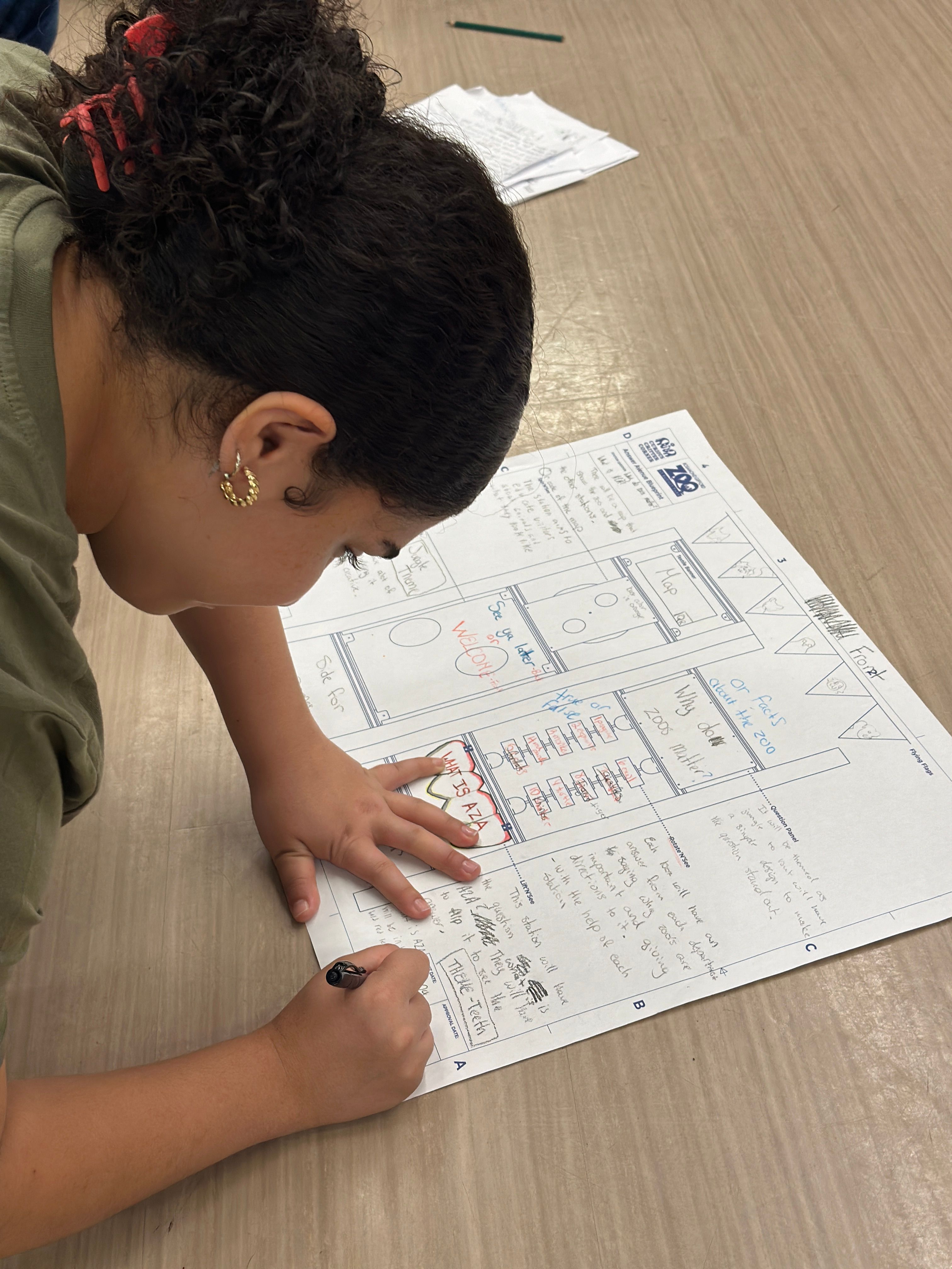 A student filling out the Curious Critter Corner station blueprint