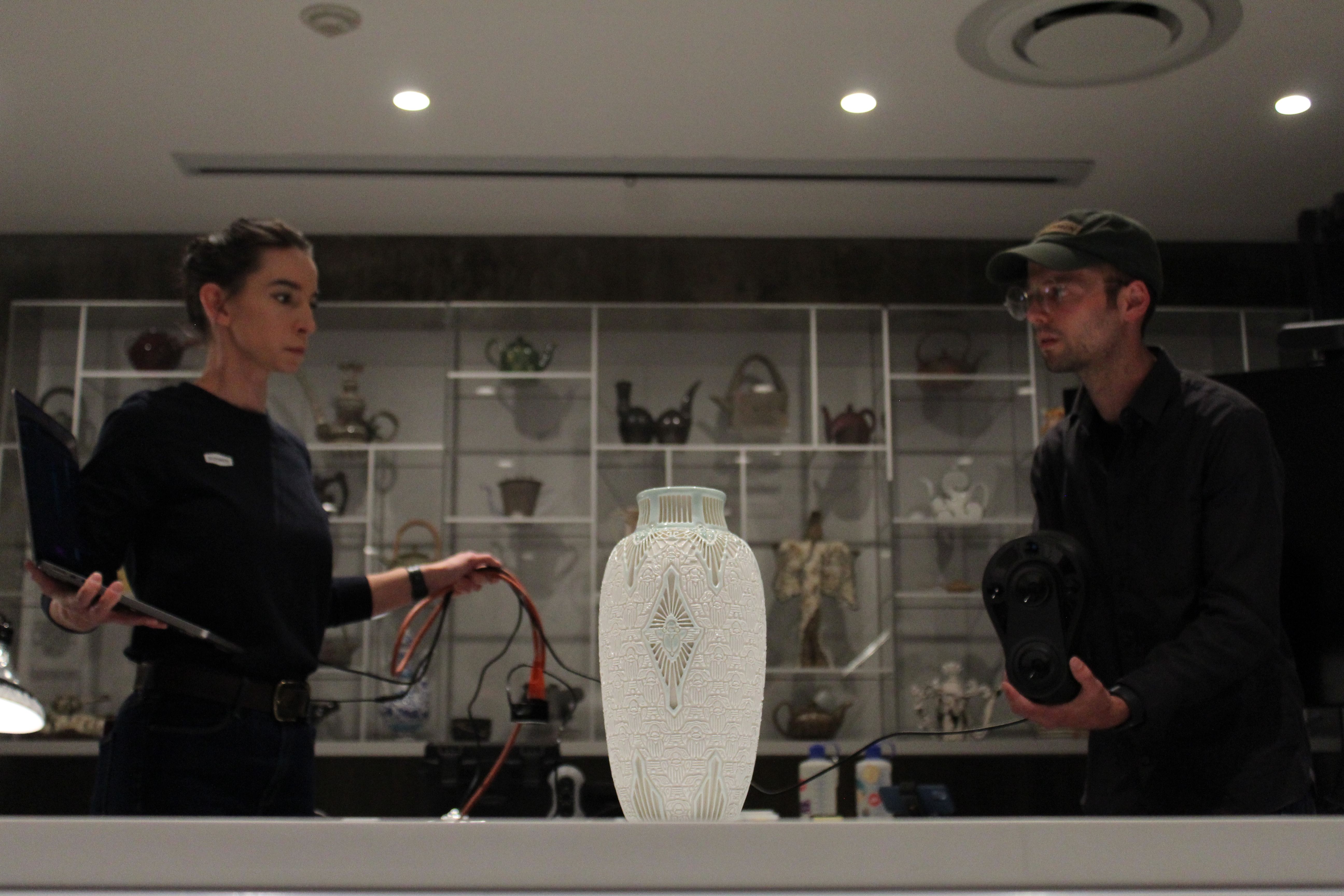 Stephanie and Isaac Budmen using an infrared scanner to capture data from the Scarab Vase