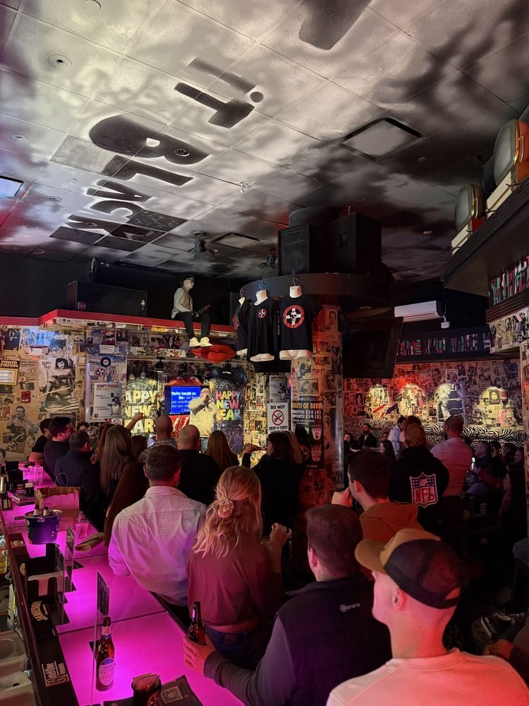 A packed Saturday crowd along the neon-lit bar