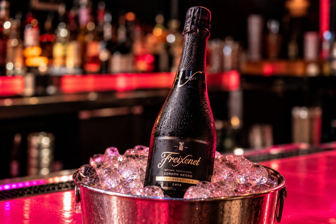 Bottle of Freixenet Cordón Negro cava chilling in an ice bucket on the pink bar