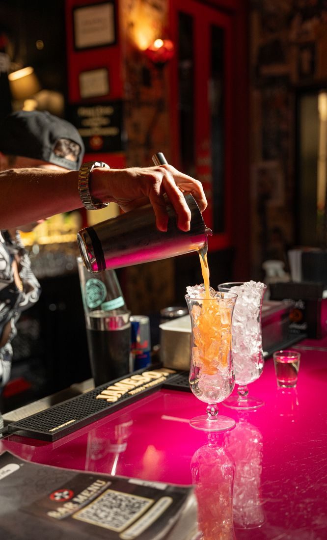 Bartender pouring a drink over ice