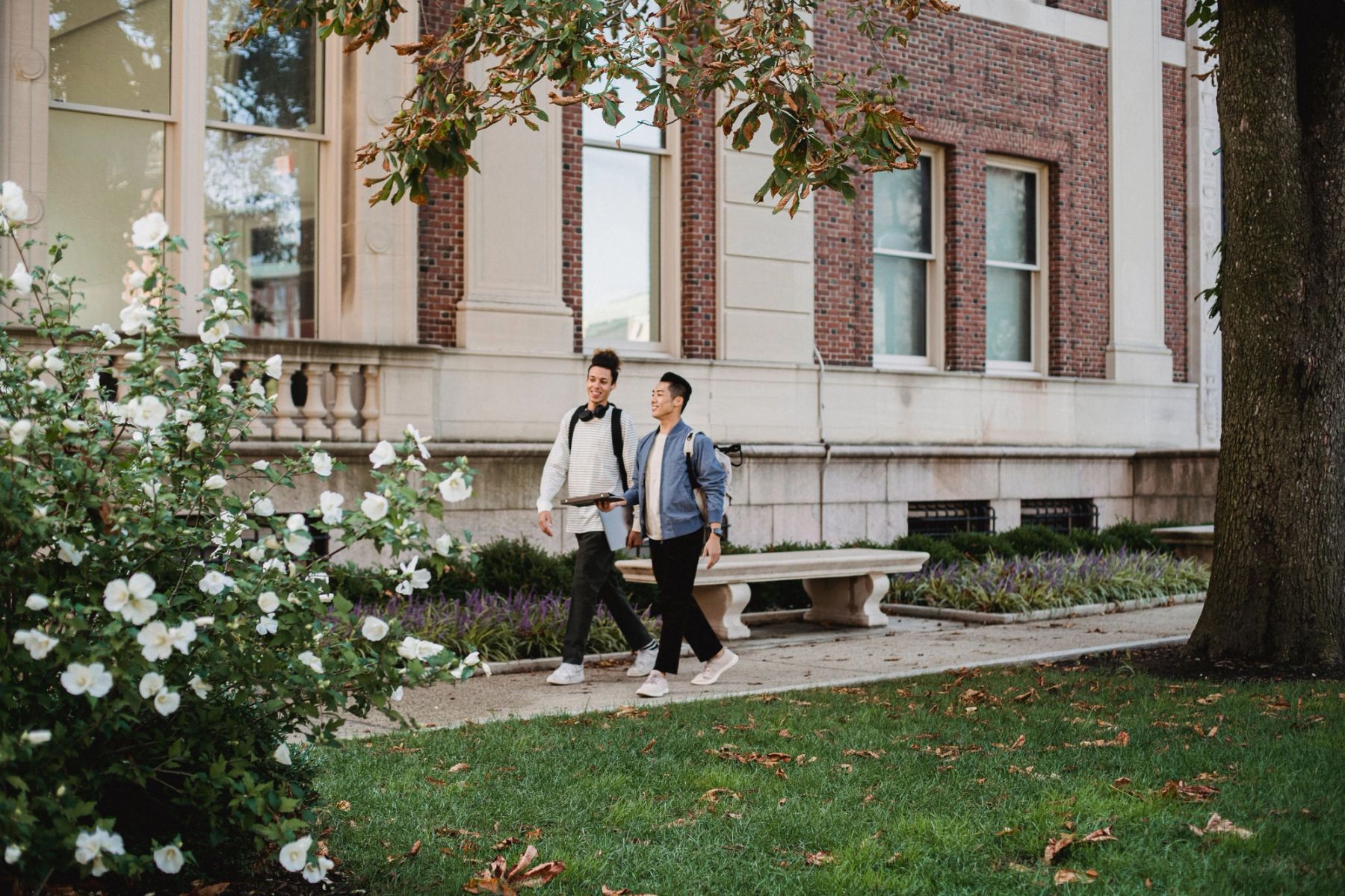 Students walking near historic stone architecture at a prestigious UK independent school campus