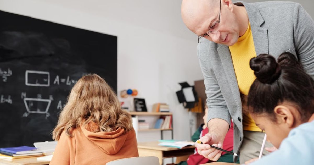 UK private school teacher supporting a student with learning differences in a modern classroom