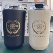 Laser engraved logo examples on black and cream insulated coffee tumblers