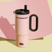 Pink insulated tumbler with black handle and lid