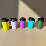 Five bright insulated coffee tumblers in natural light