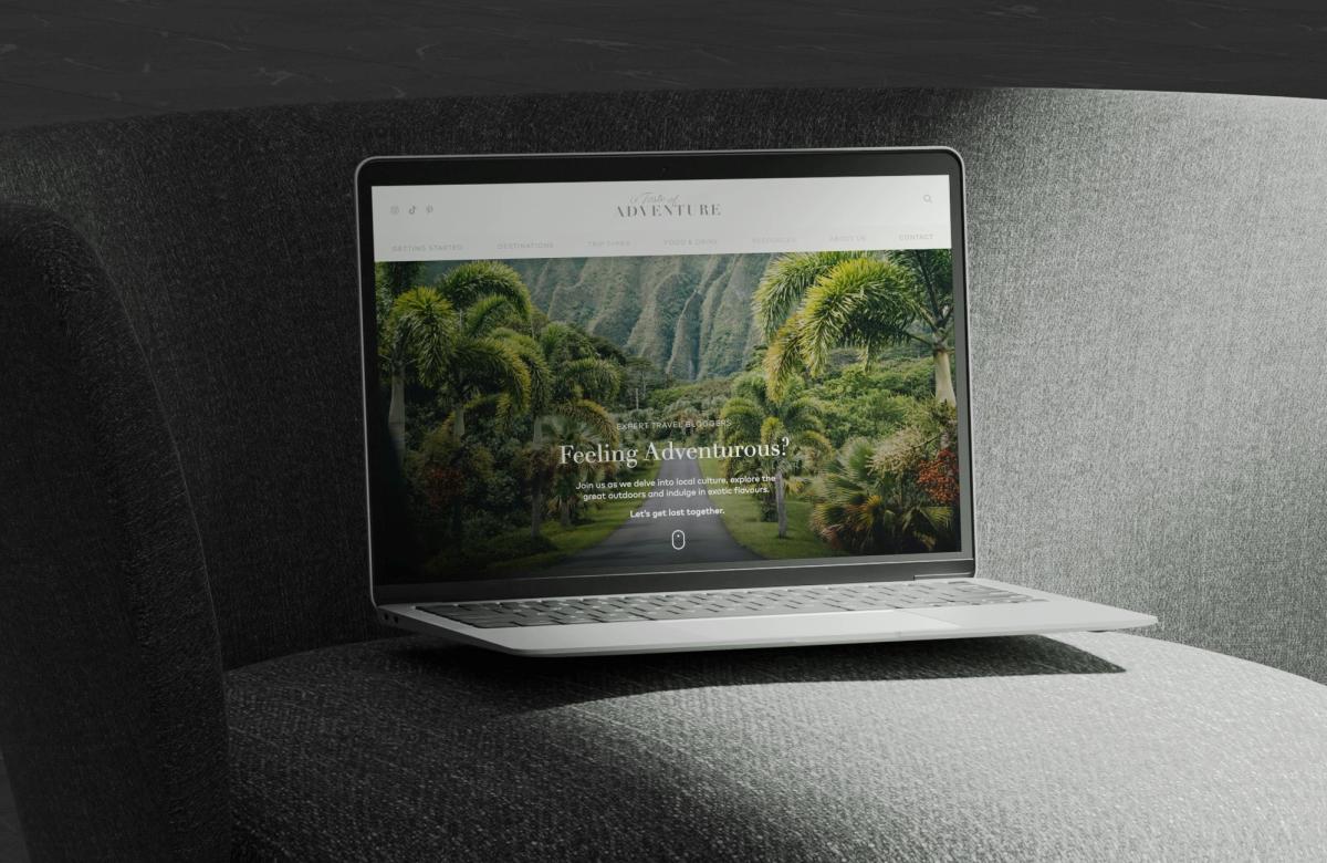 The A Taste of Adventure blog on a laptop, showing a lush landscape
