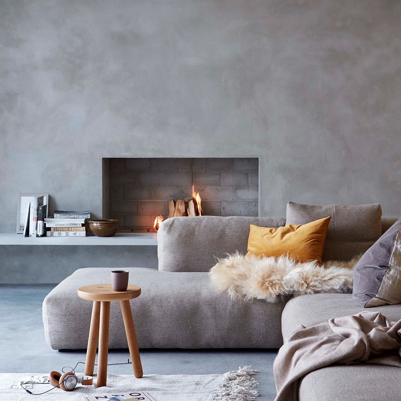 Soft grey microcement living room with a rendered fireplace and polished concrete floor