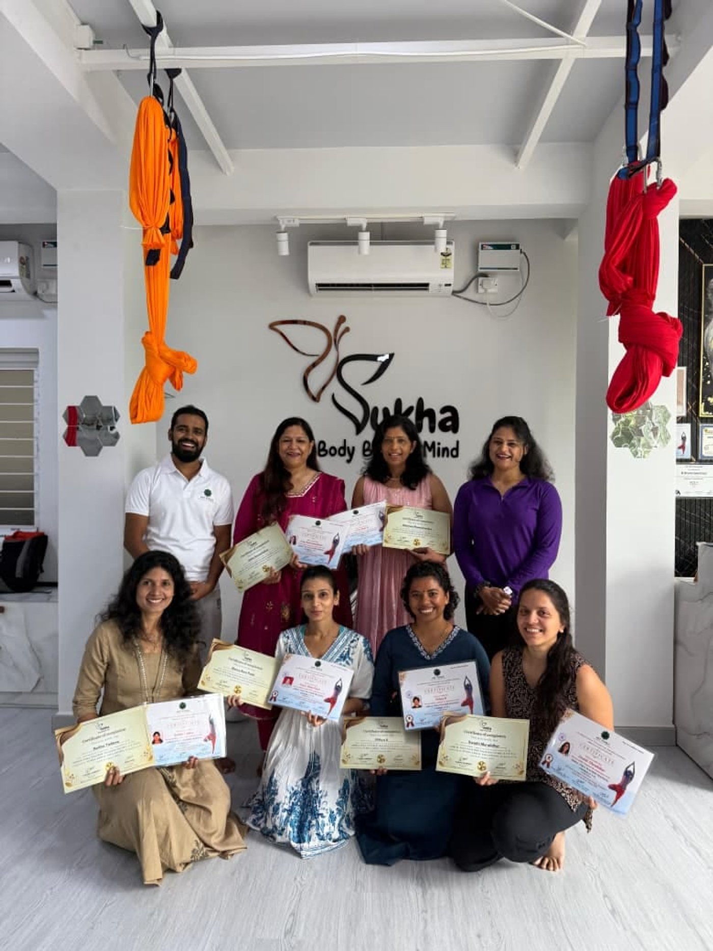 A group of certified trainers celebrating at Sukha aerial yoga studio