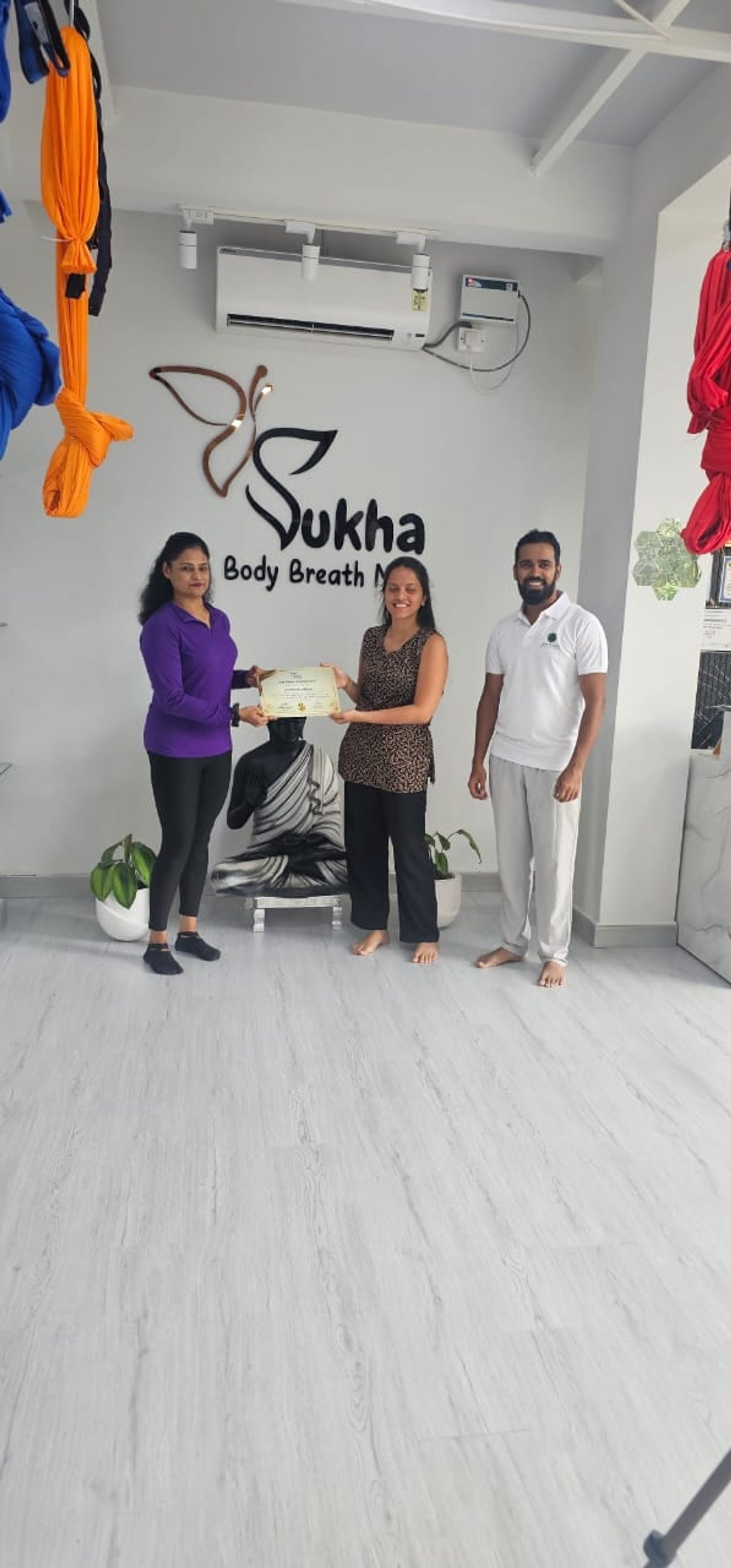 Certificate presentation with trainers and graduate at Sukha