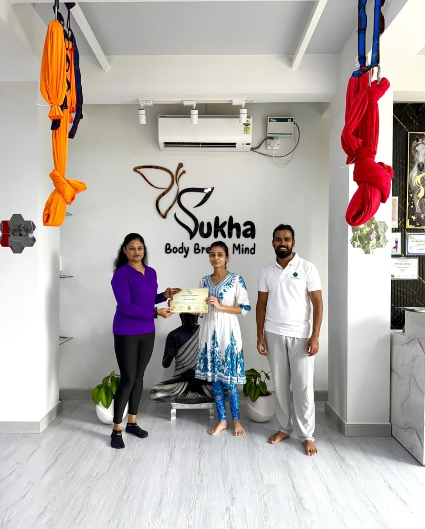 A graduate receiving her aerial yoga teacher certificate at Sukha