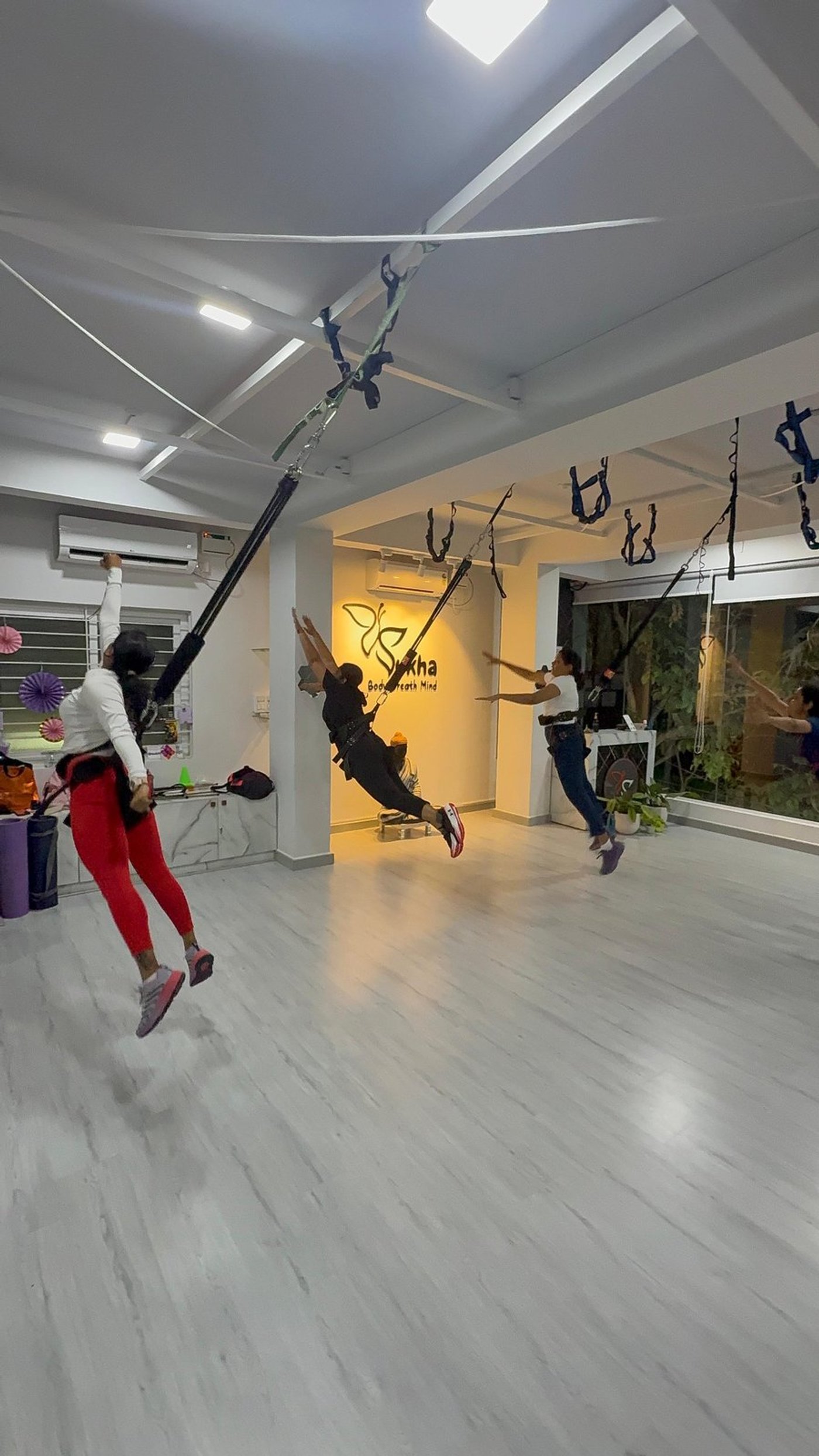Bungee Fit lean back pose with harness support in the studio