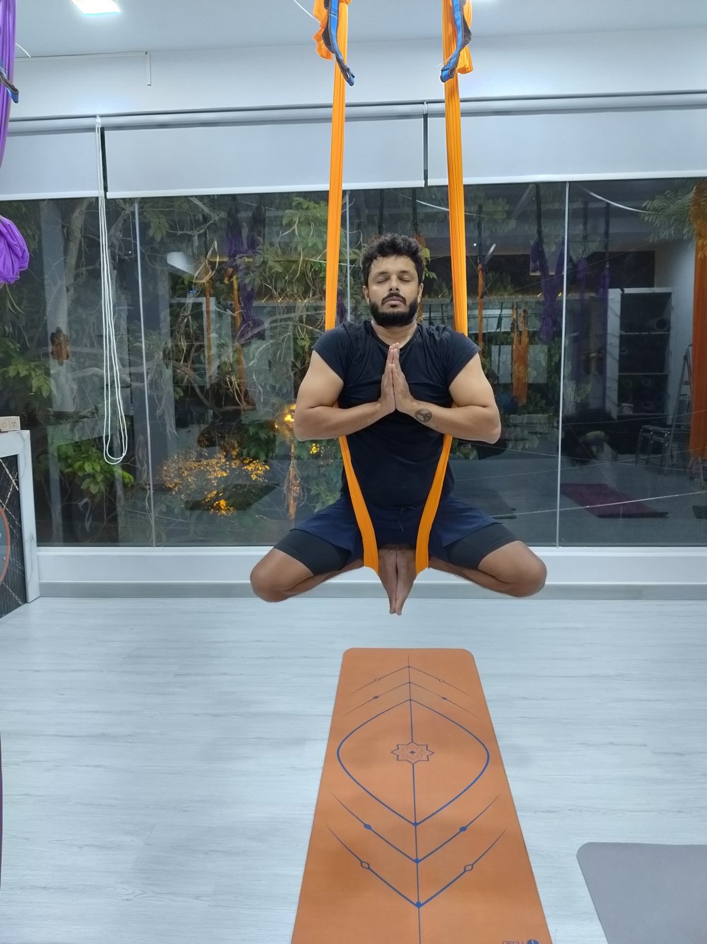 A student sitting in an aerial hammock during training
