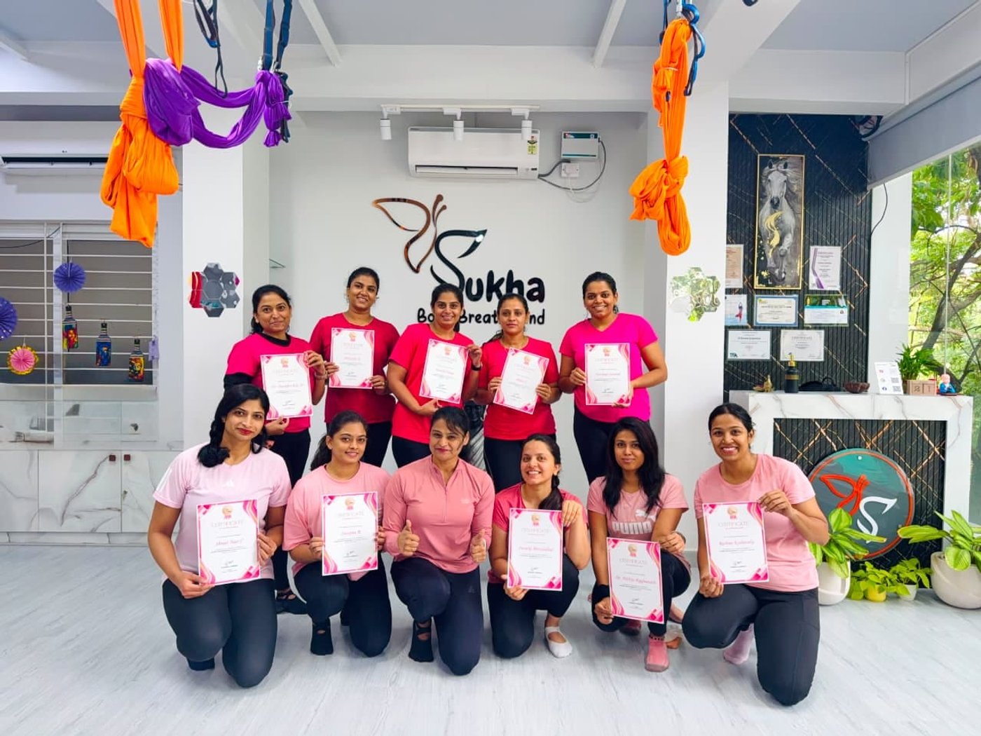 A teacher training batch holding certificates at Sukha