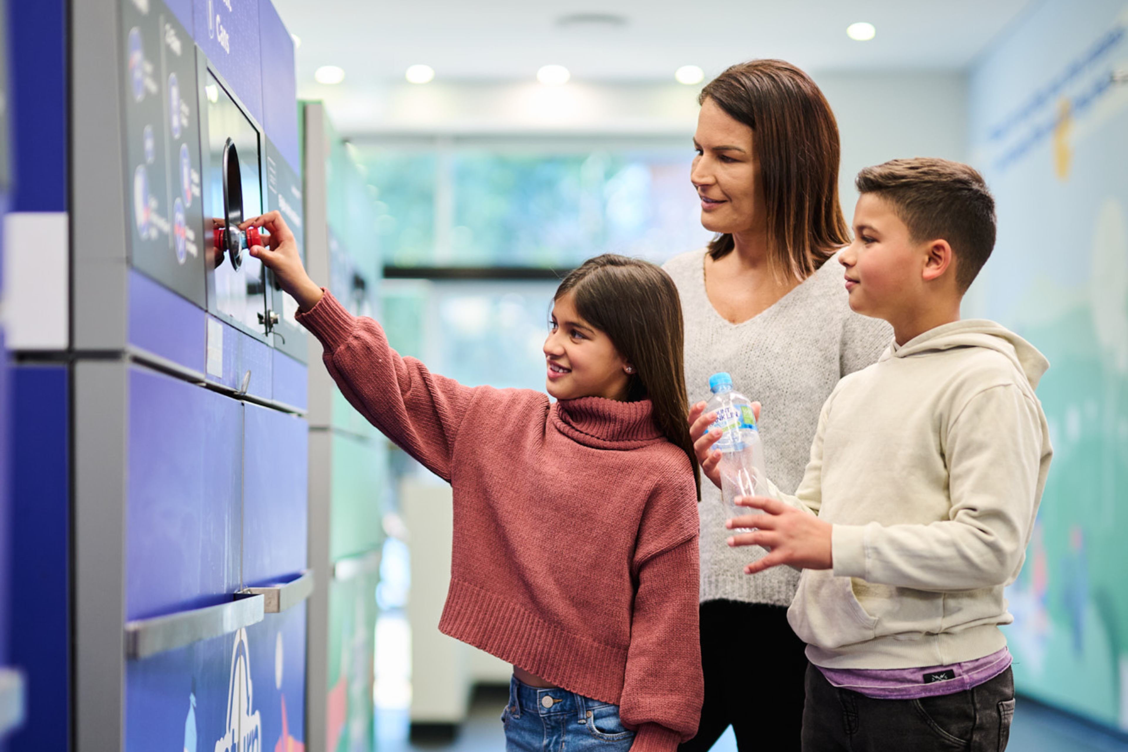 A family using a reverse vending machine to return containers