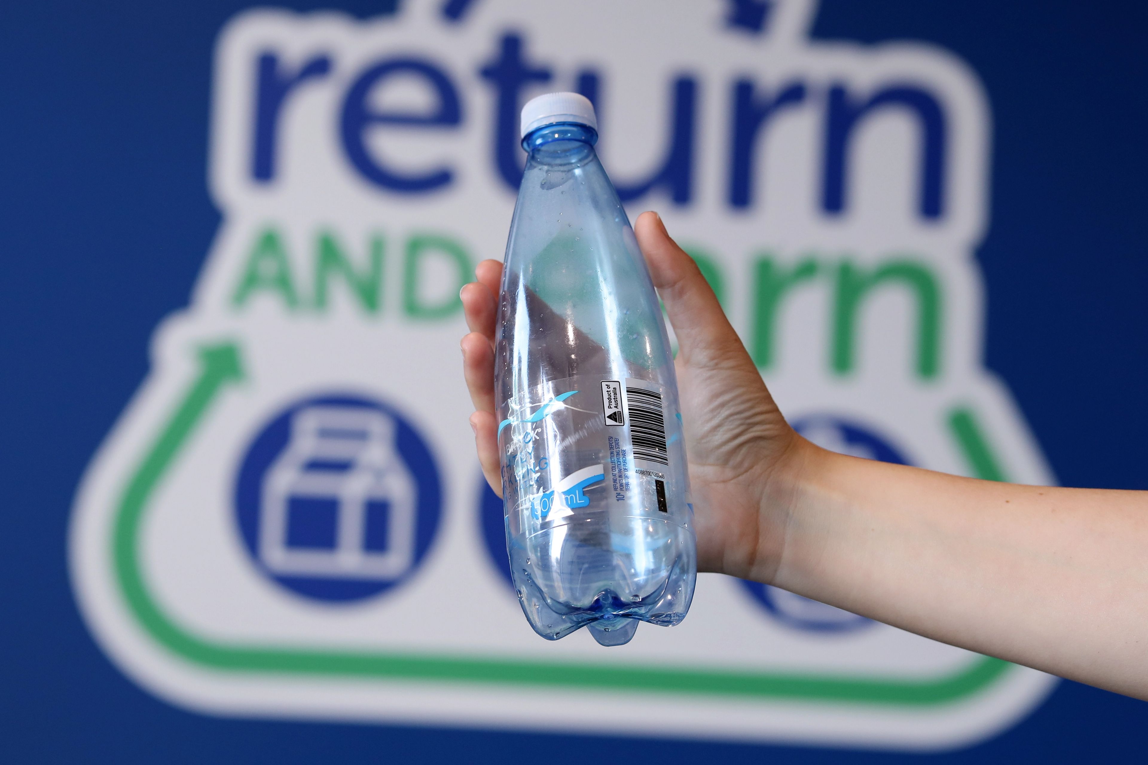 Eligible bottles being held up showing the 10c refund mark