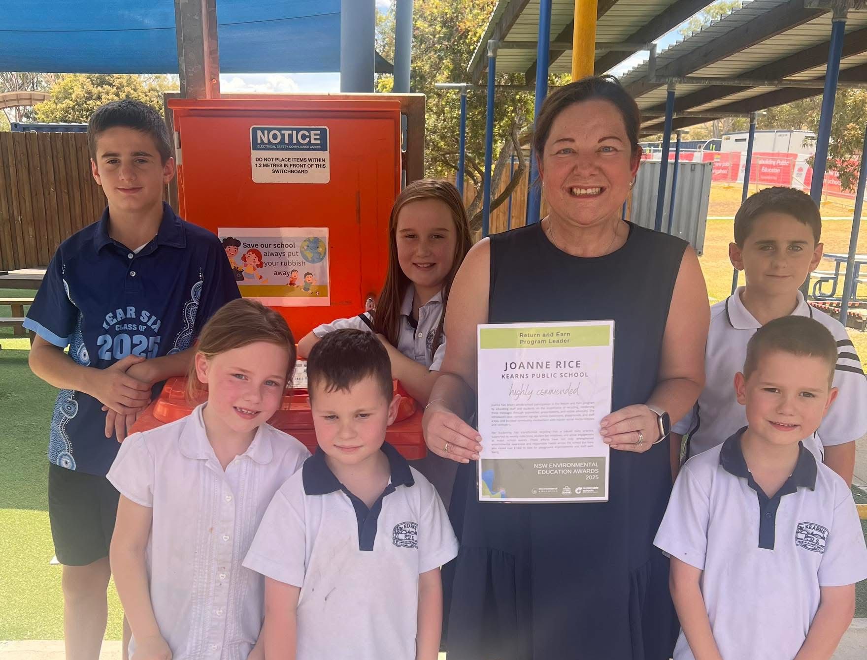 students and teacher standing with certificate