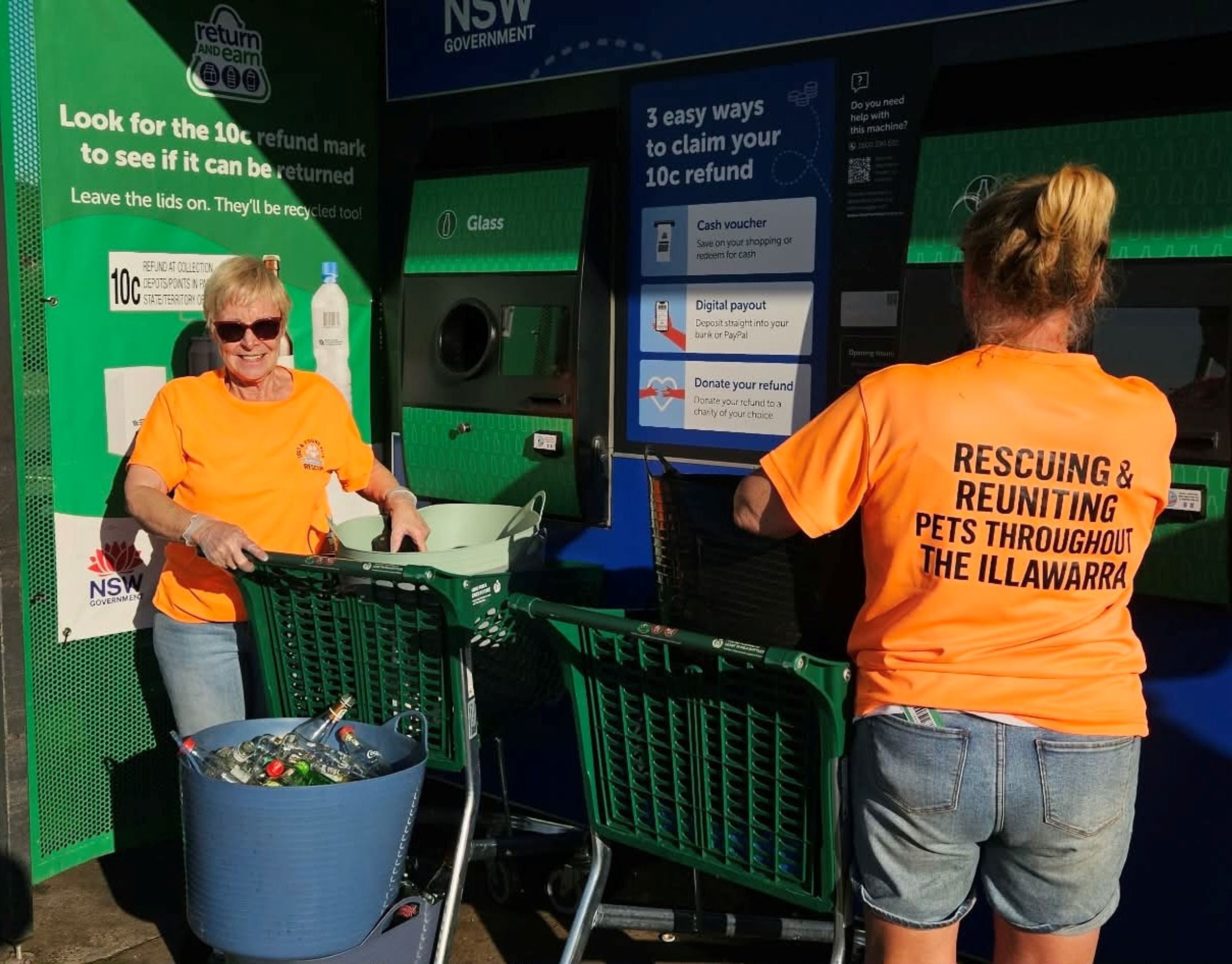 volunteers from the lost and found pets returning bottles and containers at a return point machine.