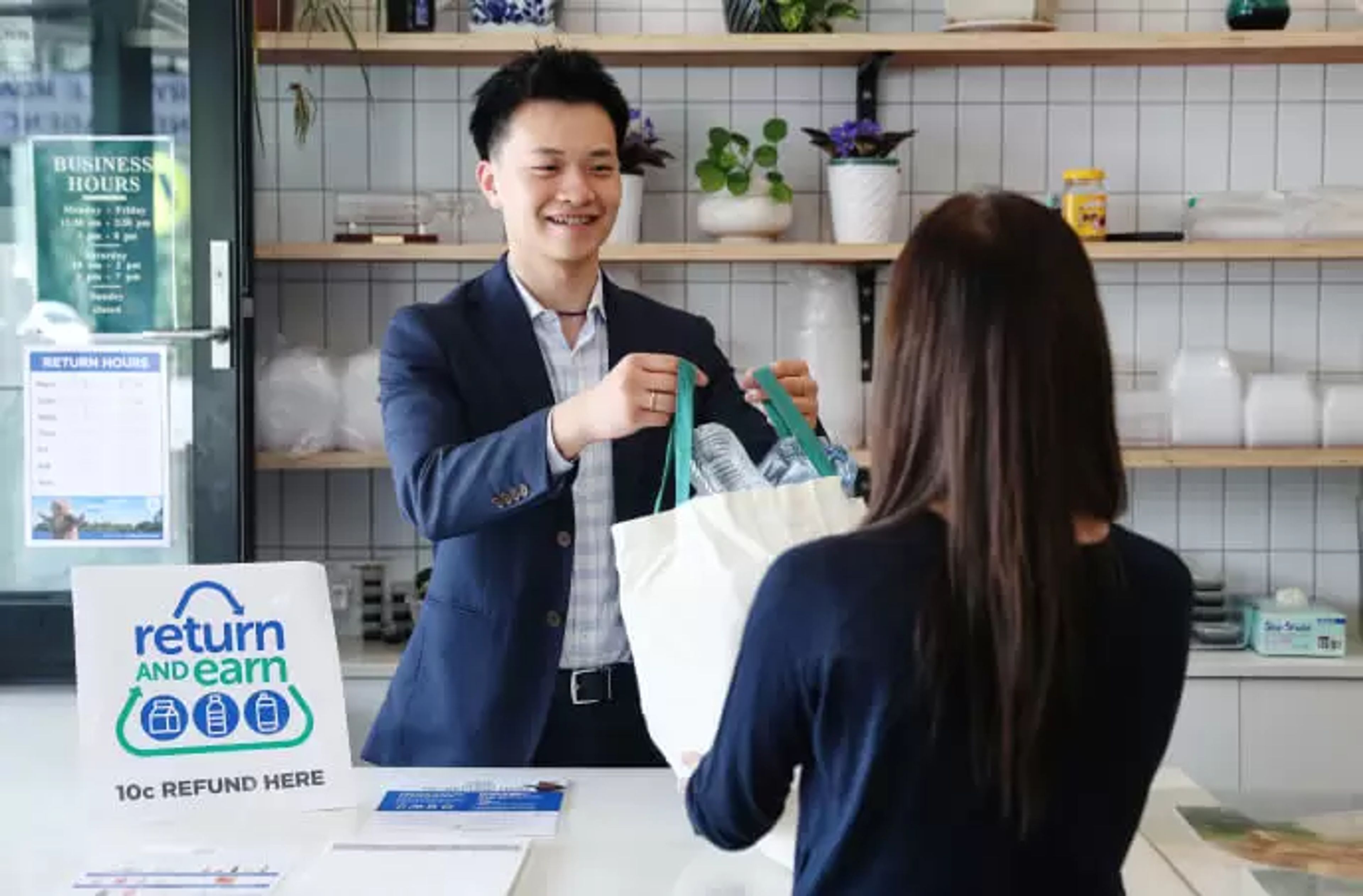 A cashier accepting a bottle for recycling