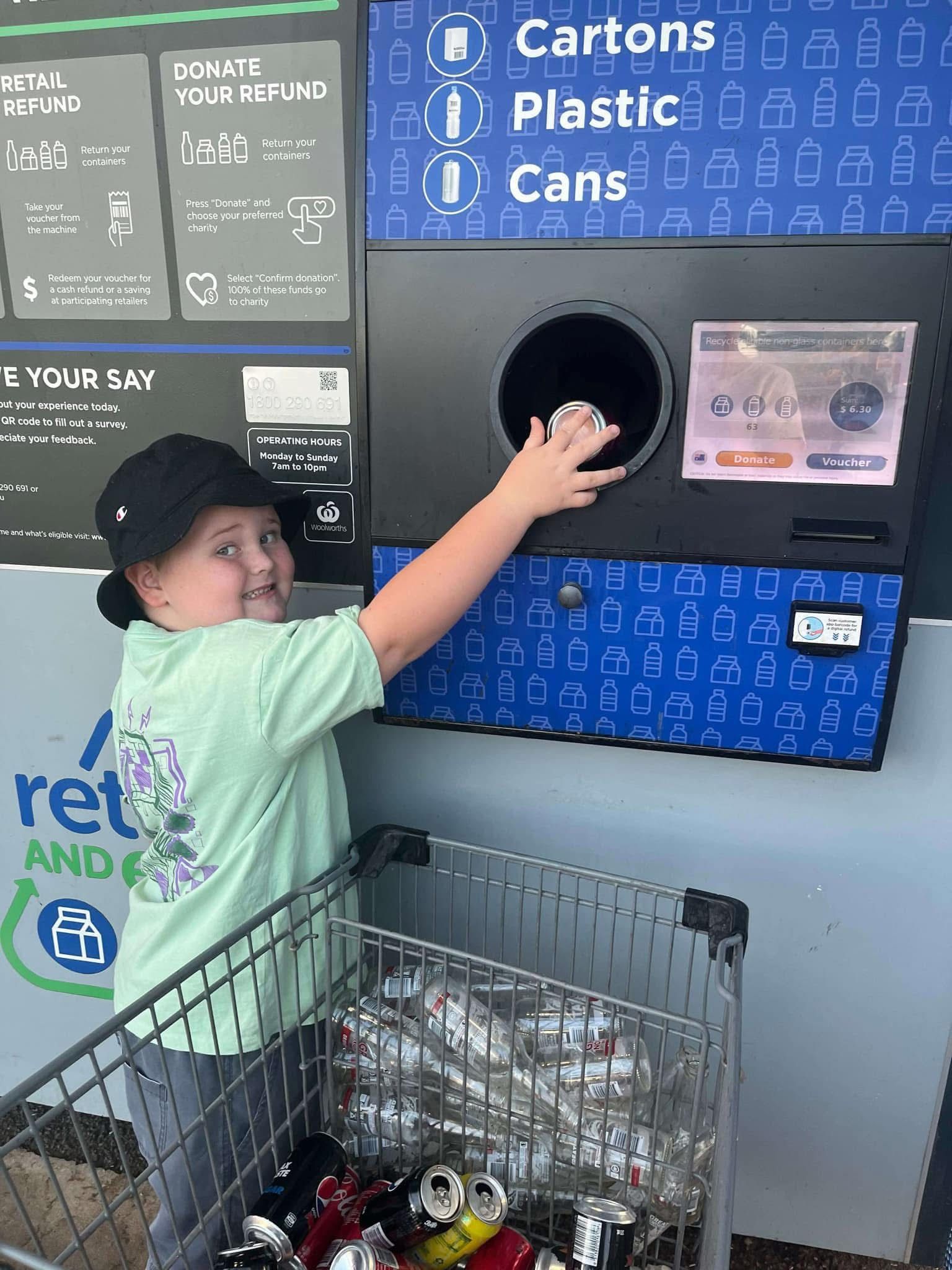 child putting containers inside a return machine