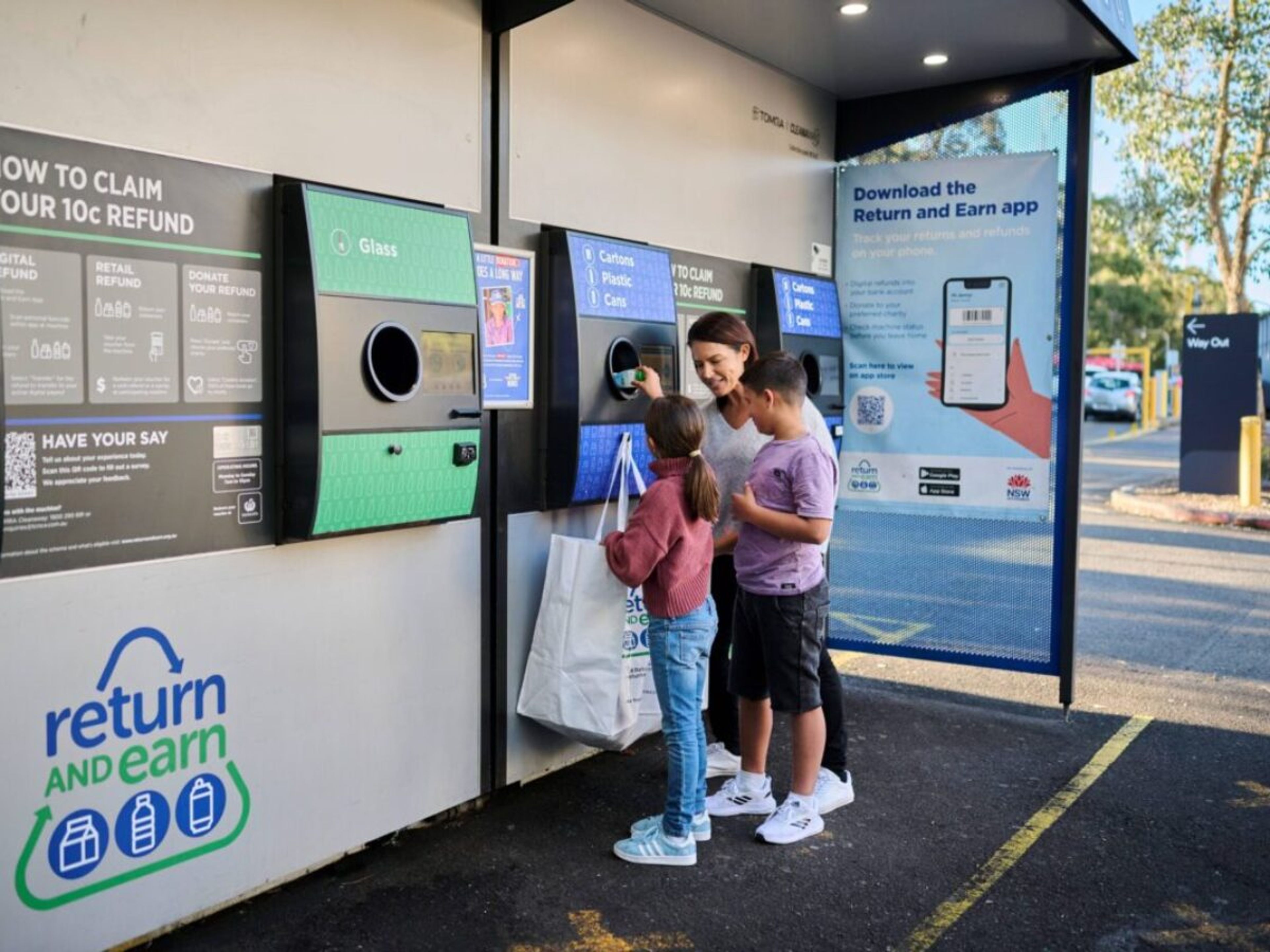 A family returning some containers at a reverse vending machine