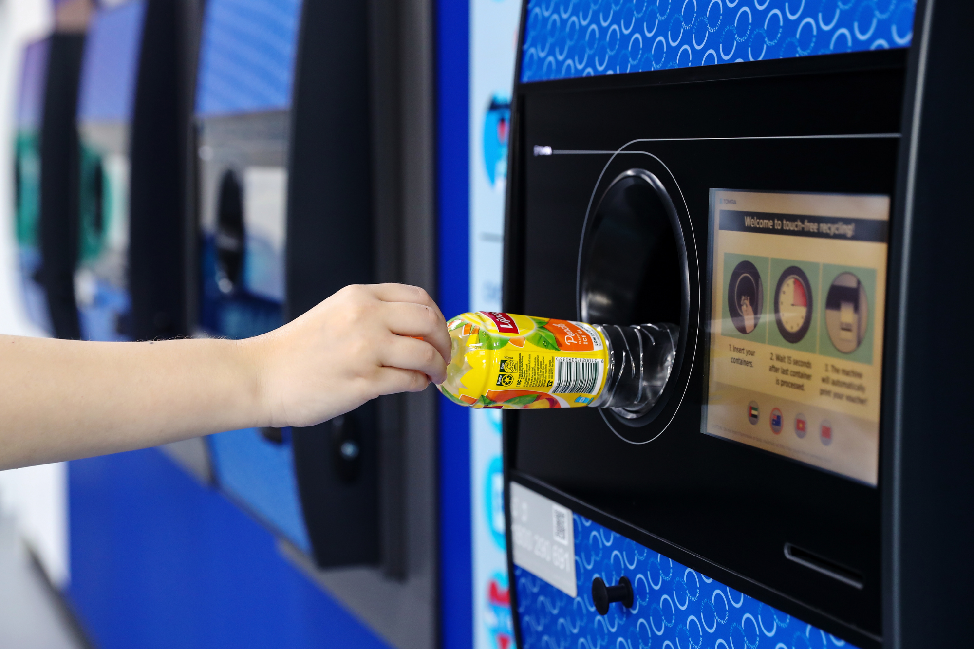 Plastic bottle being placed into Return and Earn machine