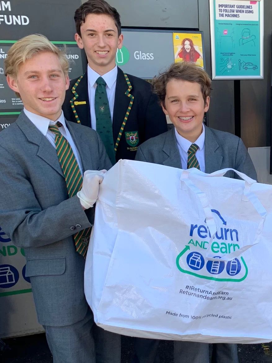 Group of students holding a return and earn bag