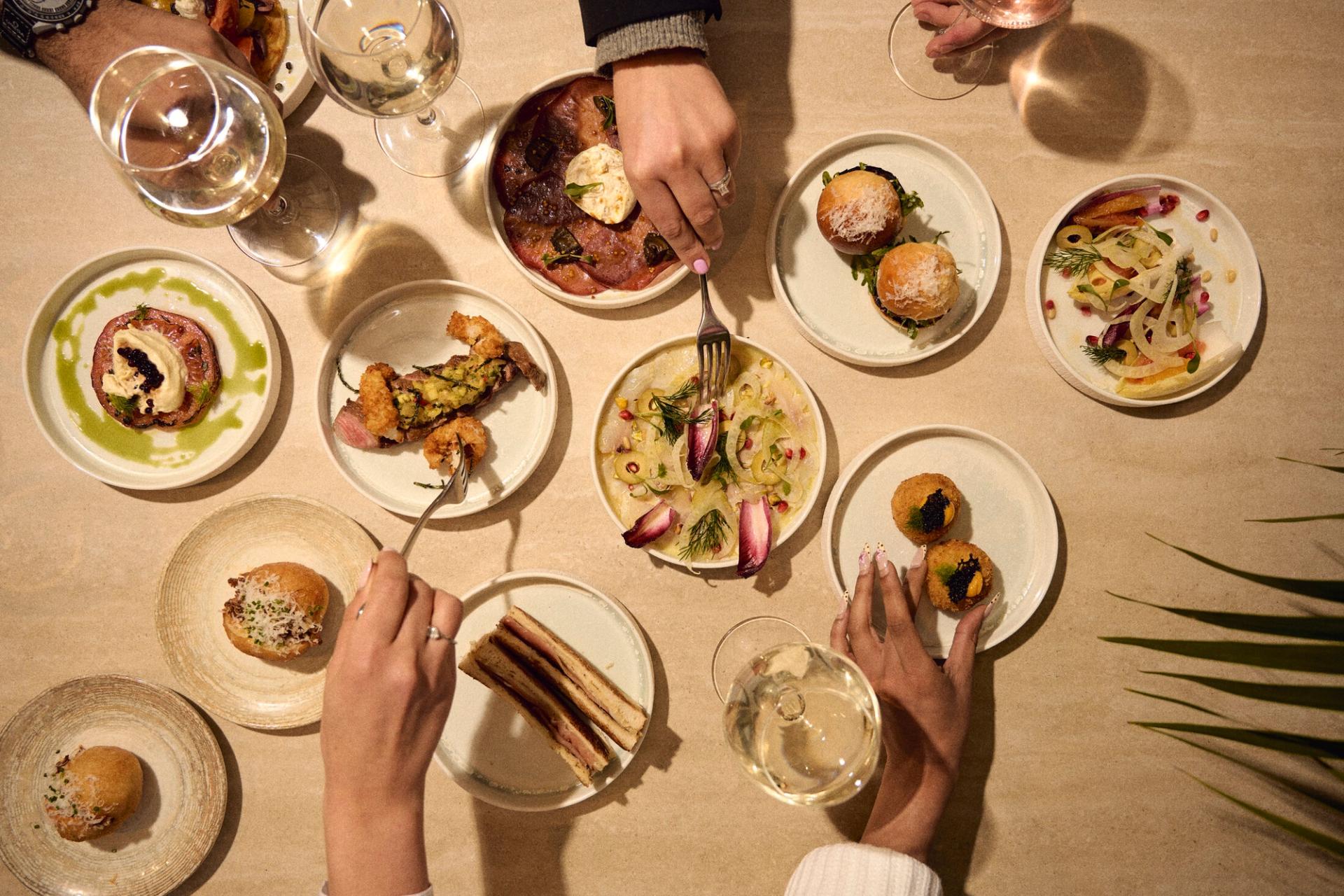 An overhead table of Piccolino sharing plates and wine