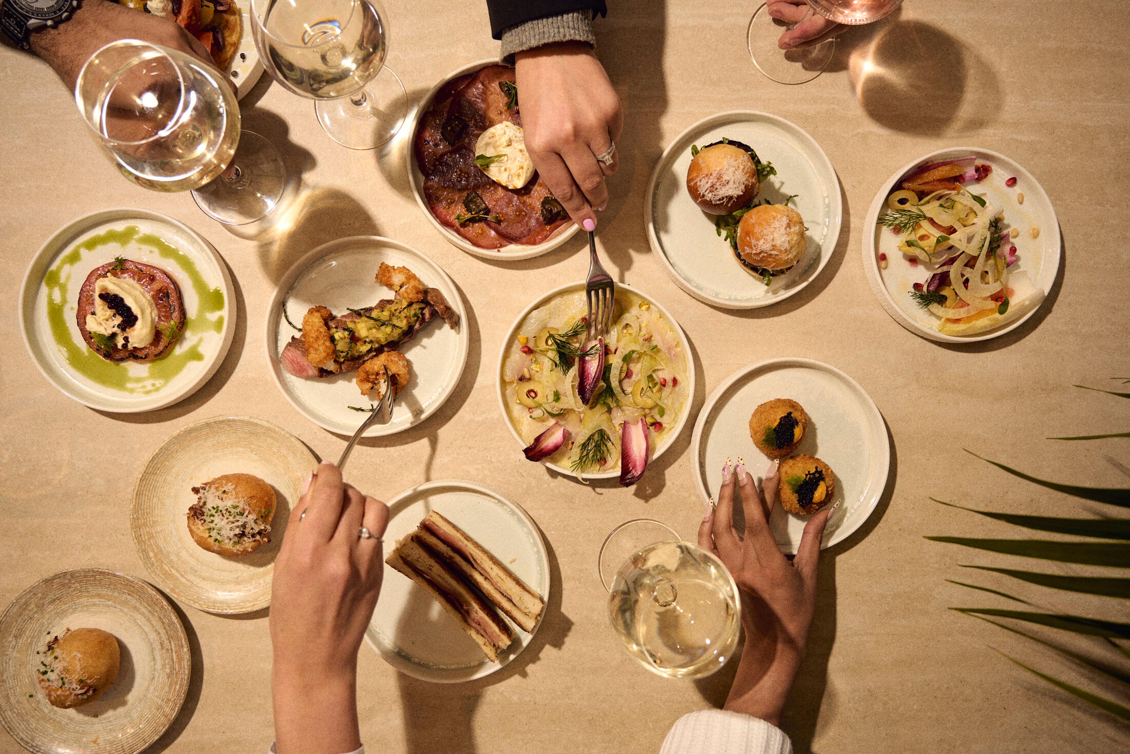 An overhead table of Piccolino sharing plates and wine