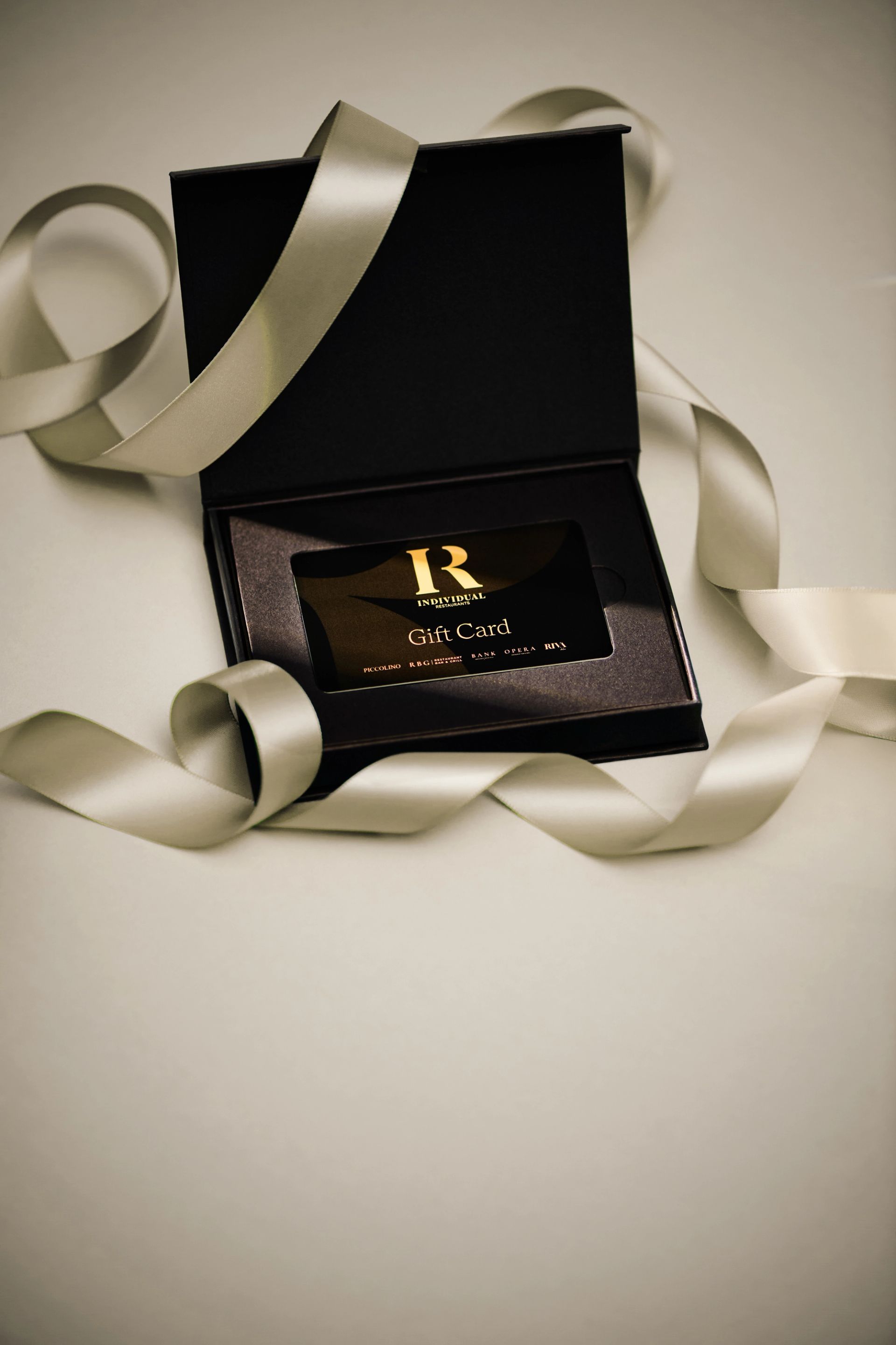A Piccolino gift card in a black presentation box with ribbon
